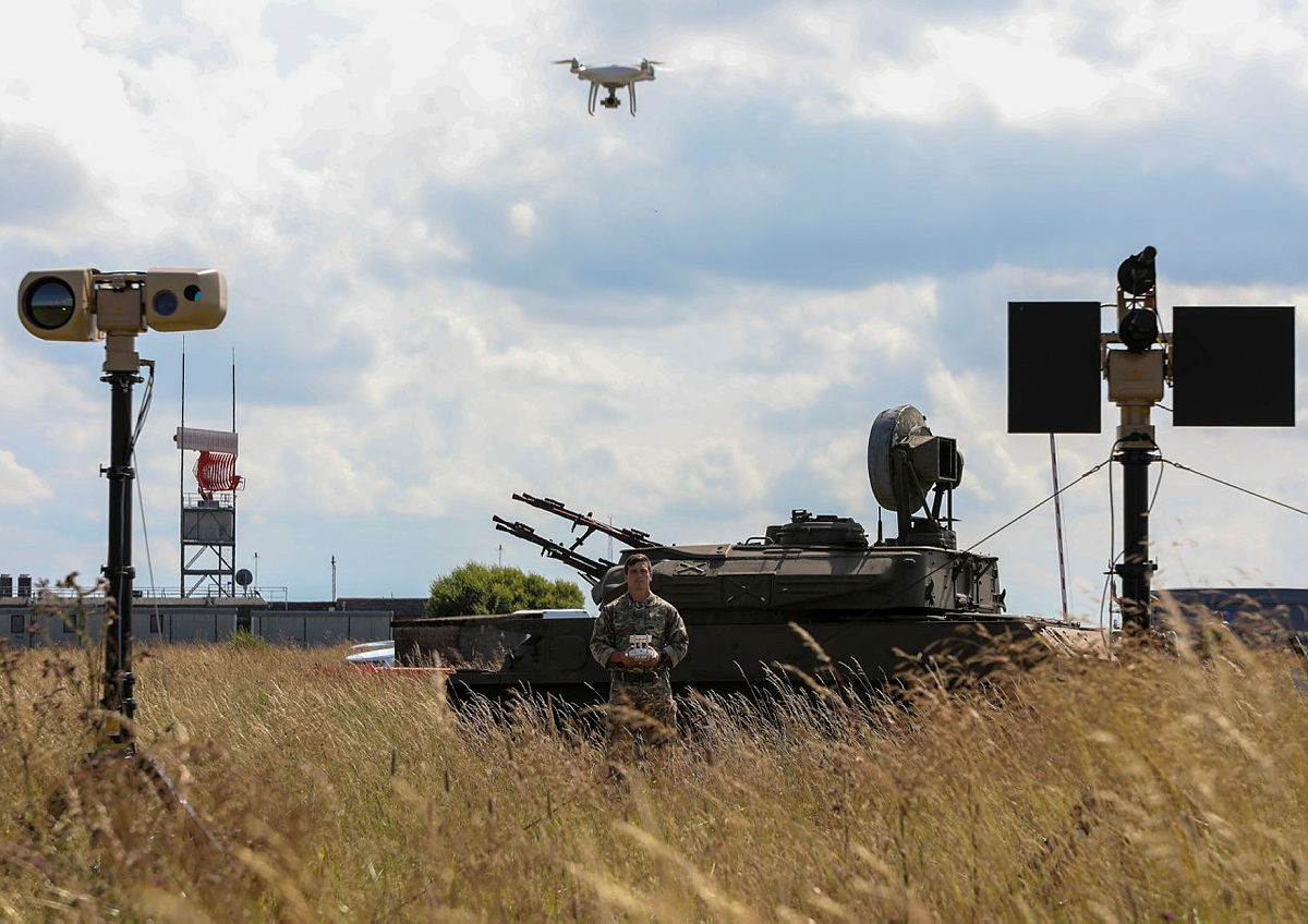 Image shows drones and surveillance equipment, with RAF Regiment standing by a tank.