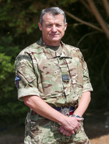 Reservists stands outside in uniform.
