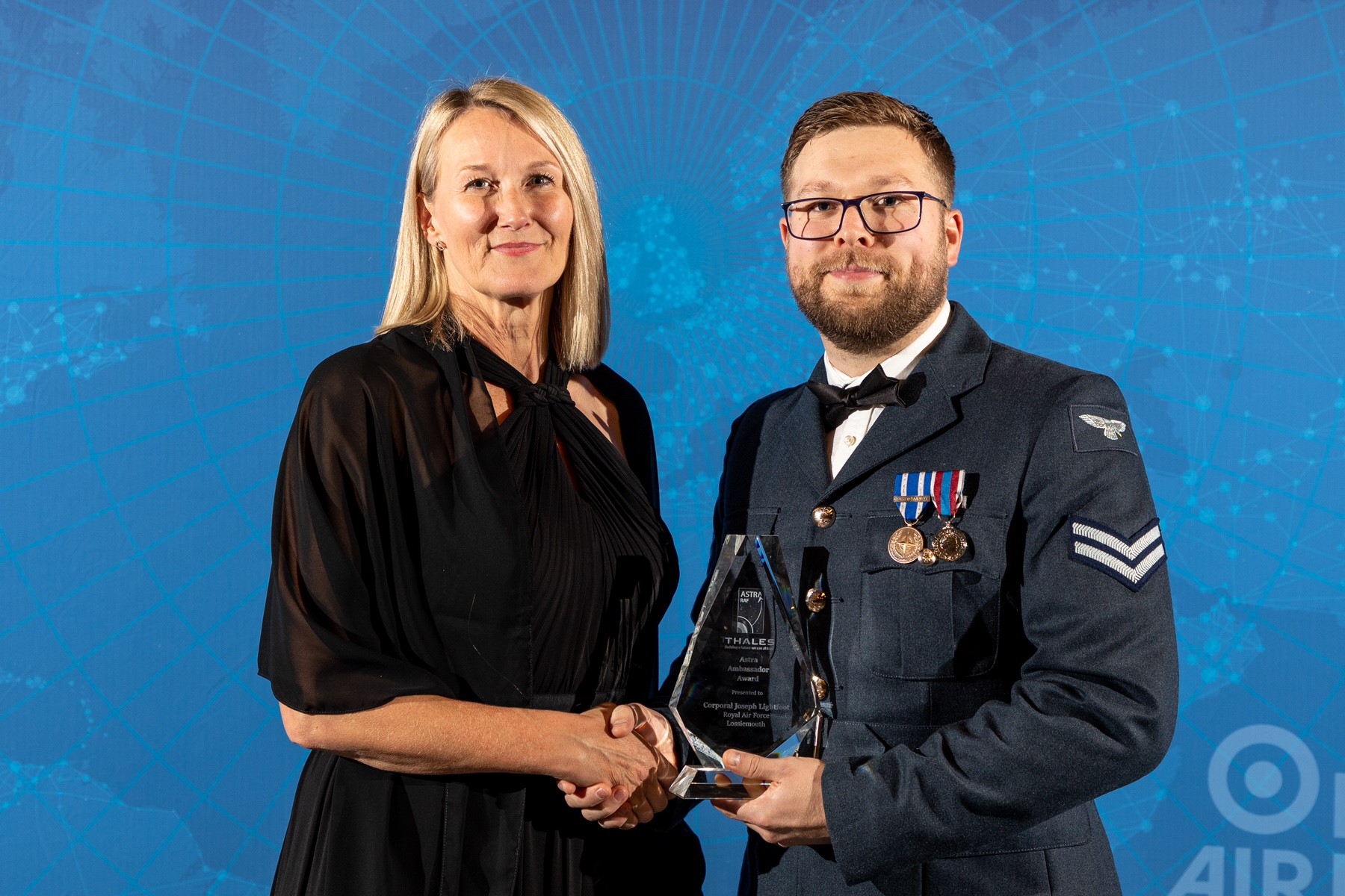 Image shows RAF aviator holding award for picture.