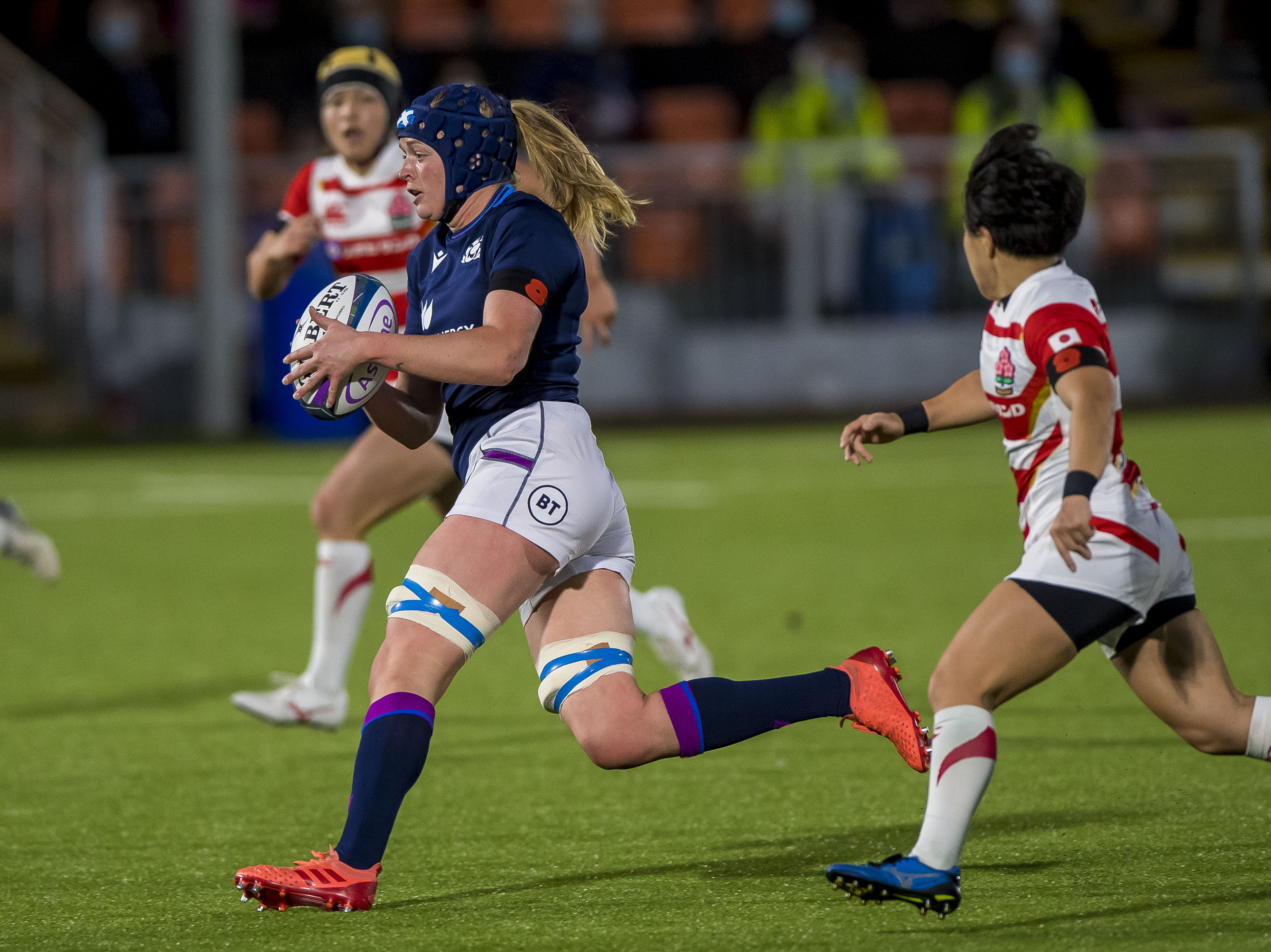 Image shows three female rugby players.