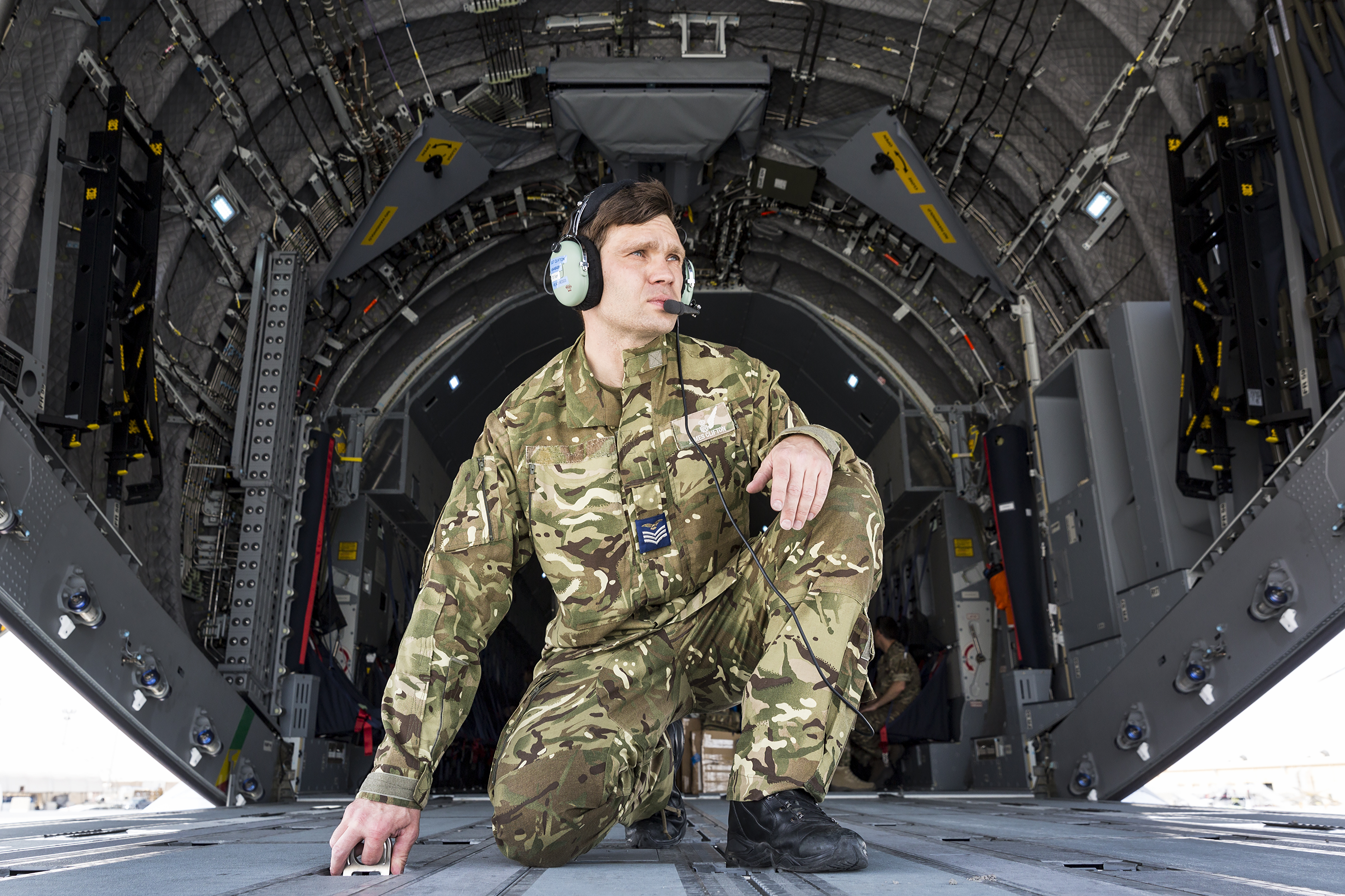 Image shows RAF Regiment kneeling in the open loading bay of aircraft.