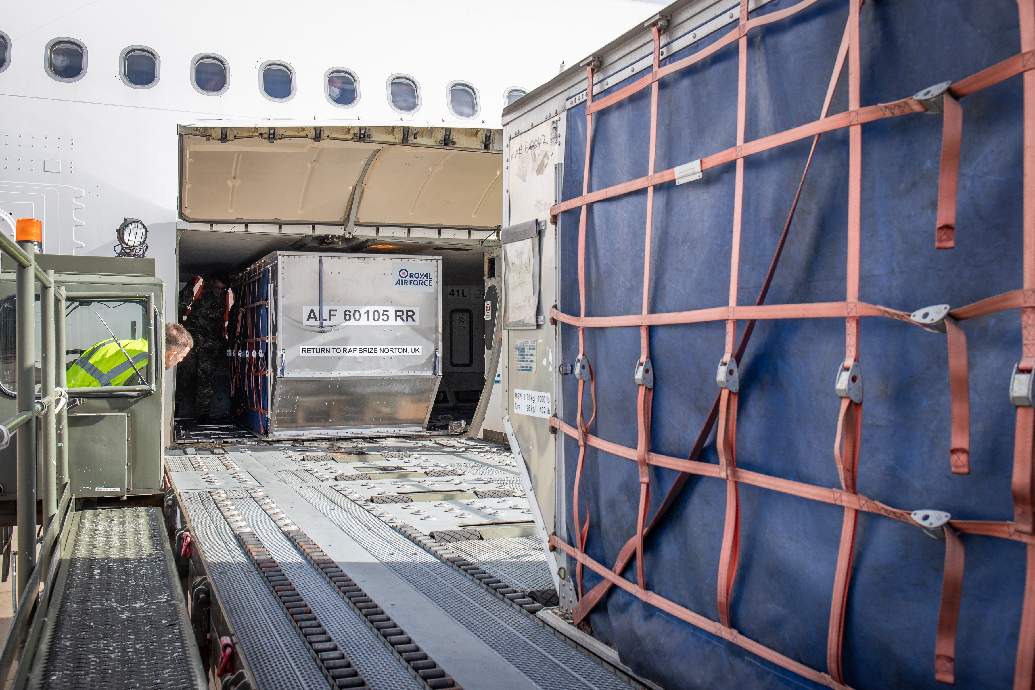 Metal cargo container moved on escalator into carrier aircraft.