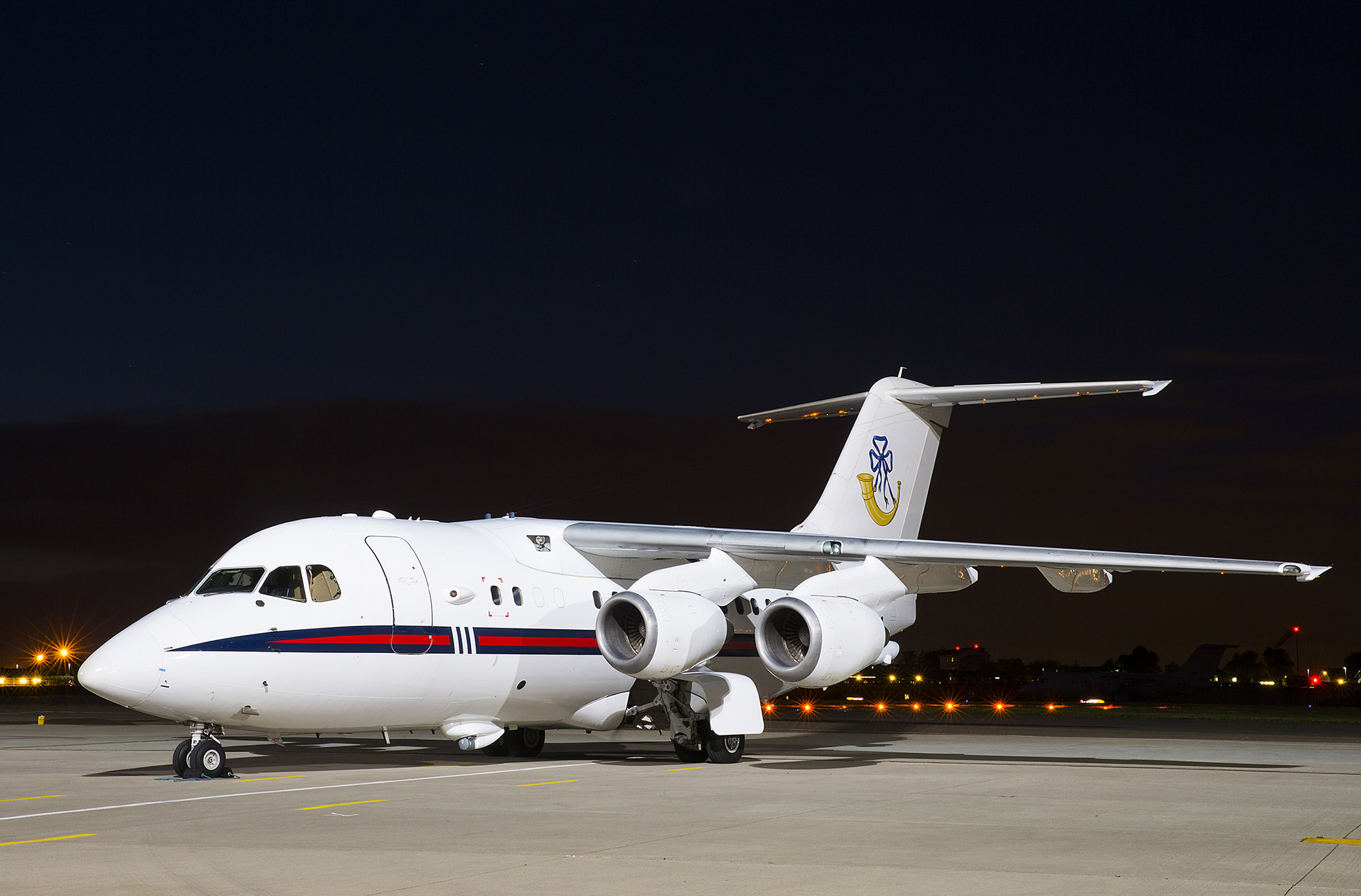 BAe146 aircraft on the airfield at night.