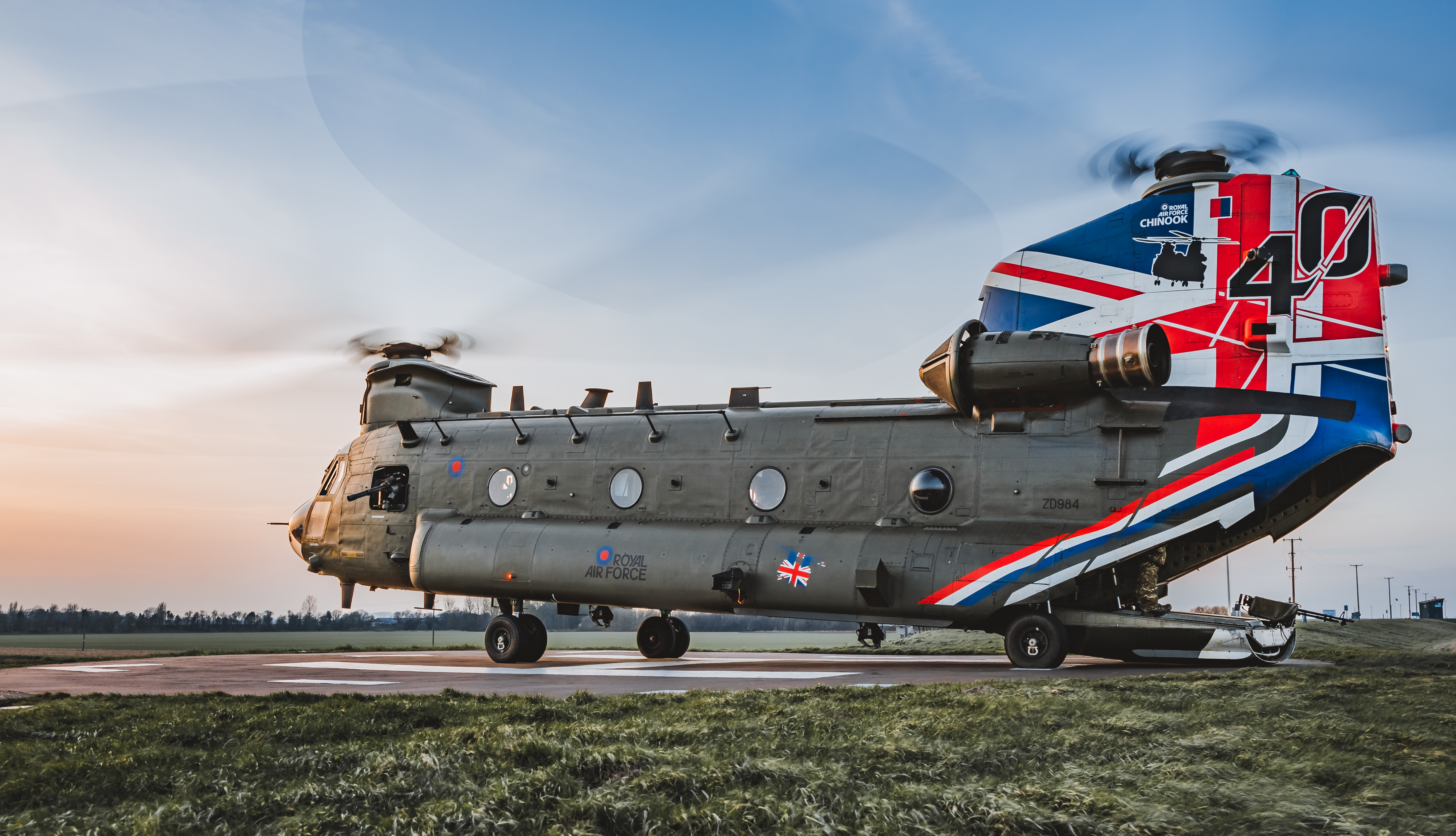 Image shows Chinook with Union Jack bodypaint on the airfield and its cargo bay open.