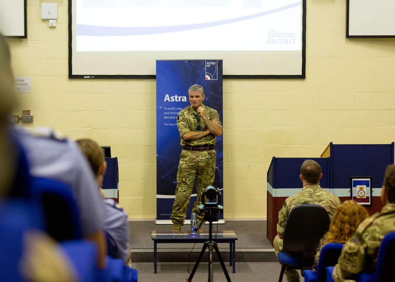 Image shows aviator presenting to others with camera recording him.