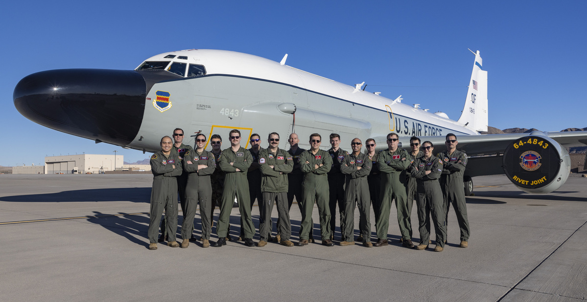 Image shows the aircrew standing by a Rivet Joint aircraft.