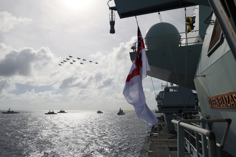 Two F-35B Lightnings fly in formation over Aircraft carriers.