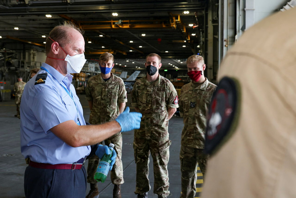 Air Chief Marshal Wigston and personnel standing inside hangar.