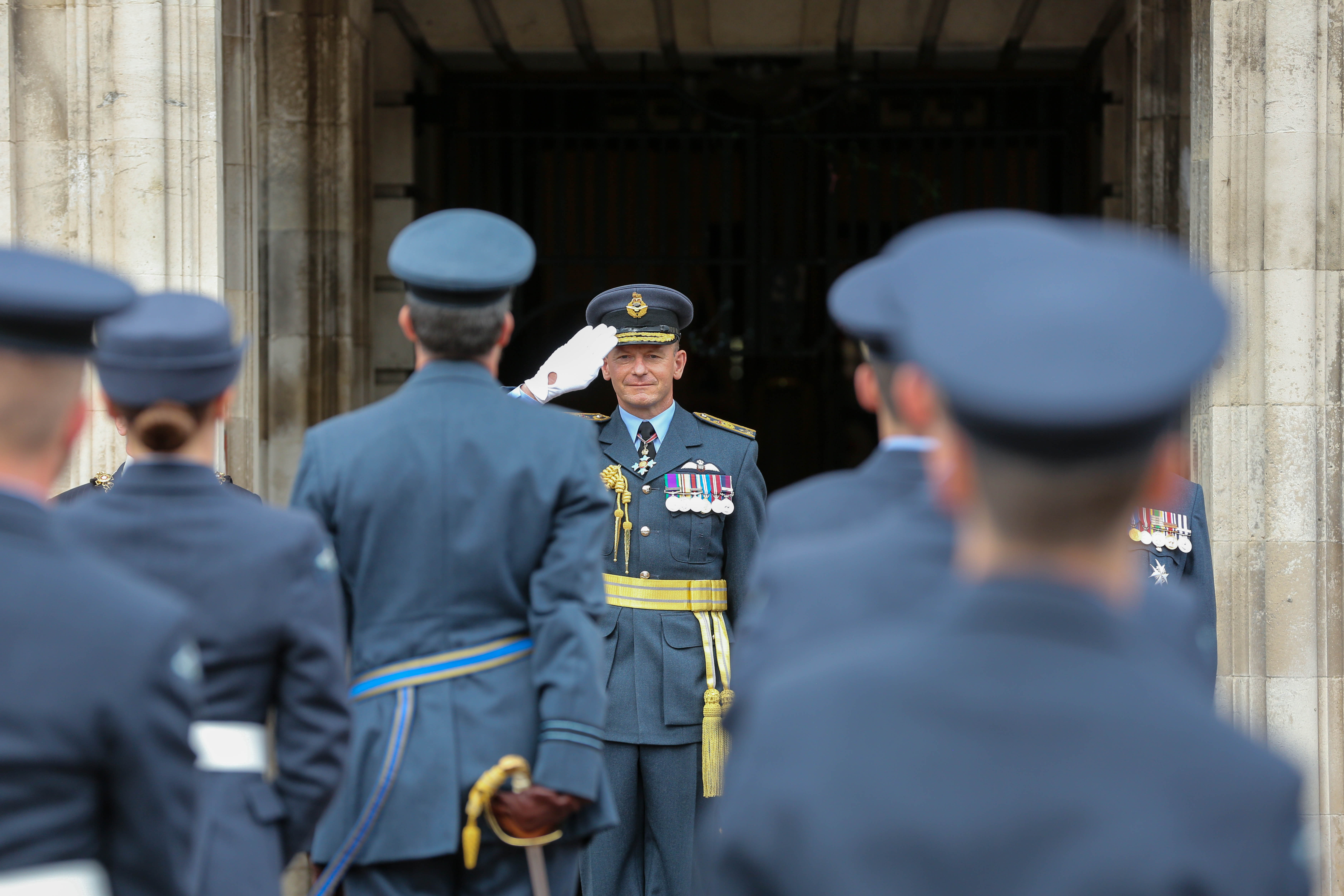 Air Chief Marshal Mike Wigston salutes to onlooking personnel.