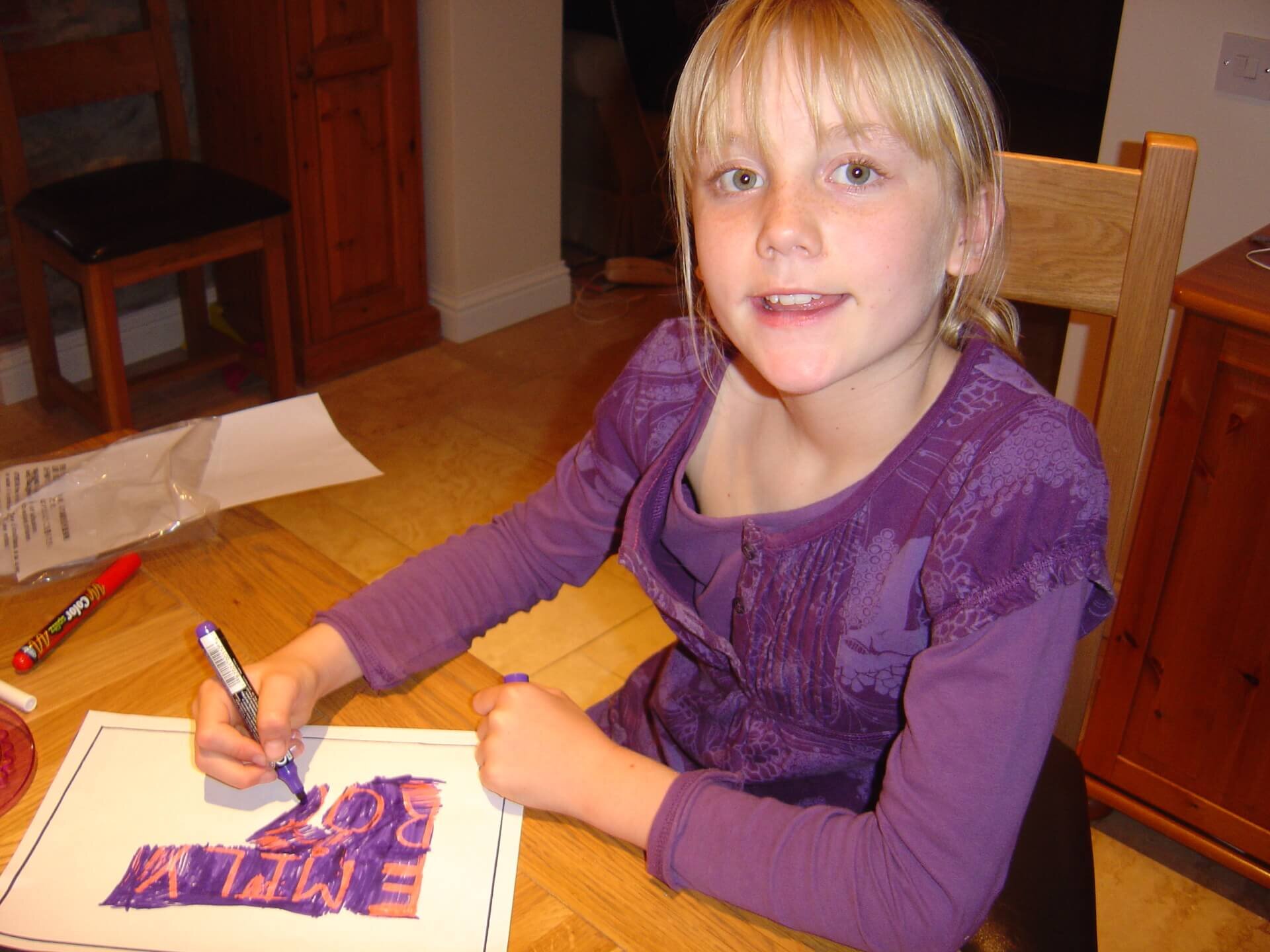 Young Emily colouring in at a table.