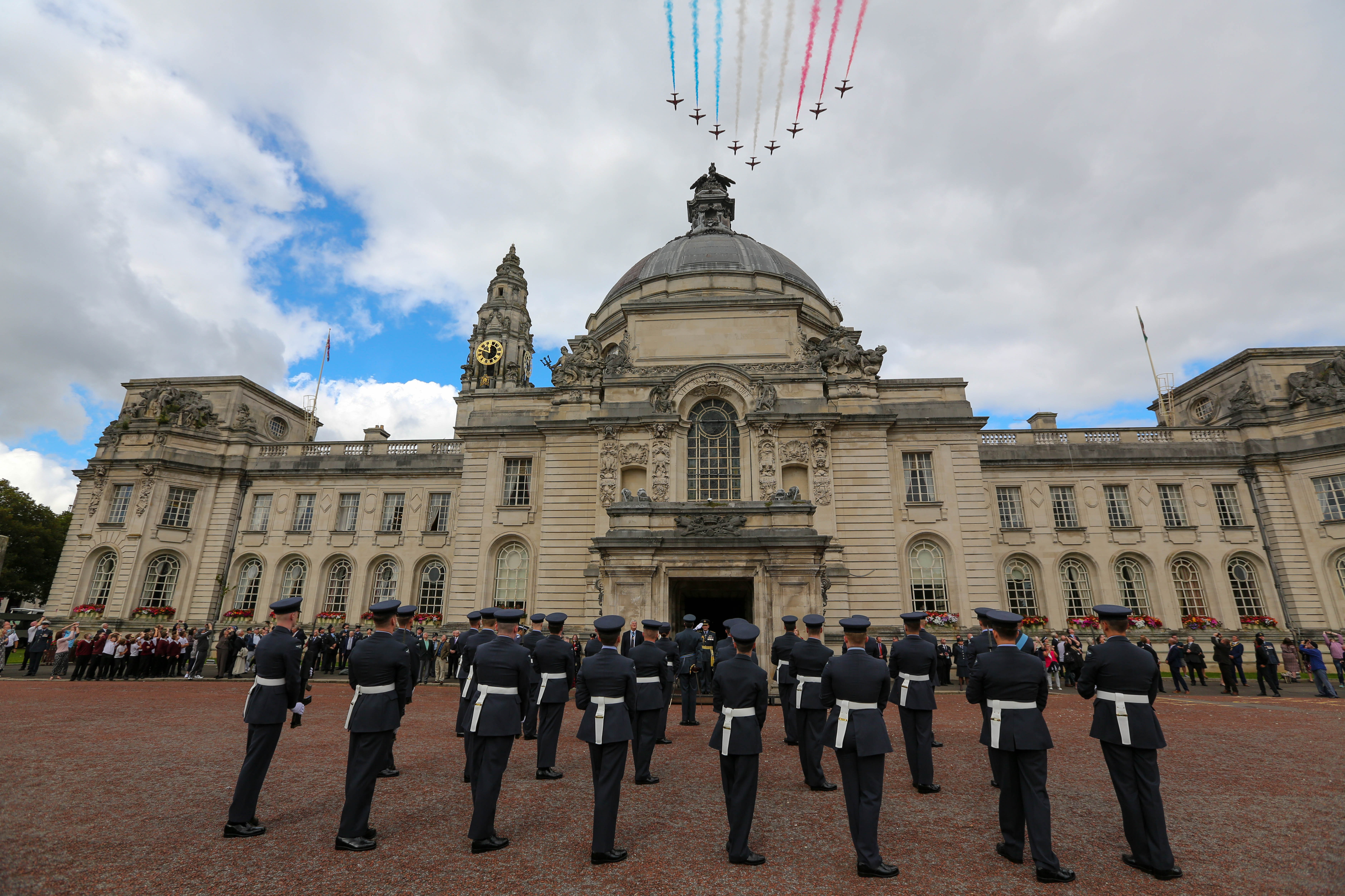 Red Arrows fly over parade and building