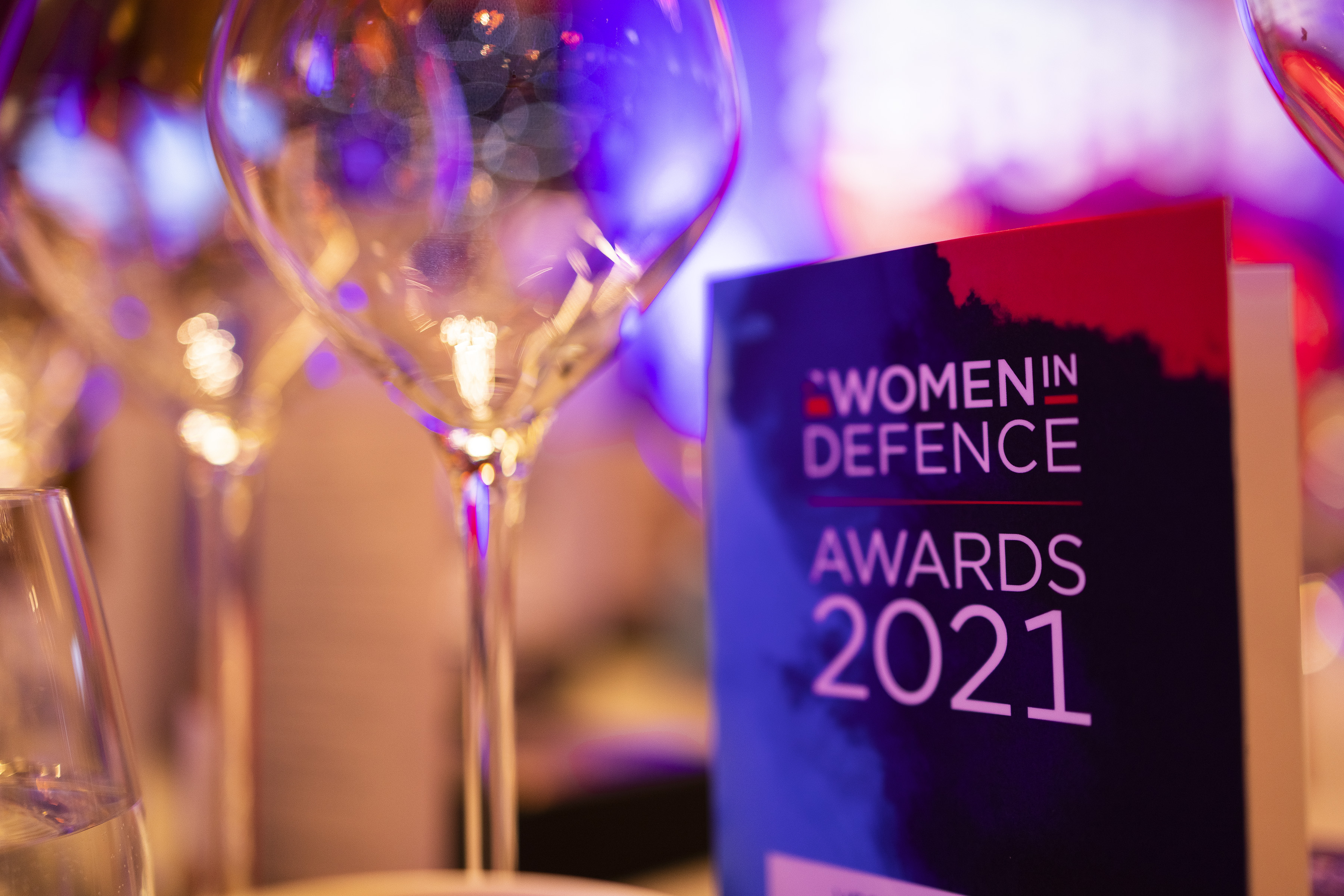 Women in Defence 2021 award next to champagne glasses.