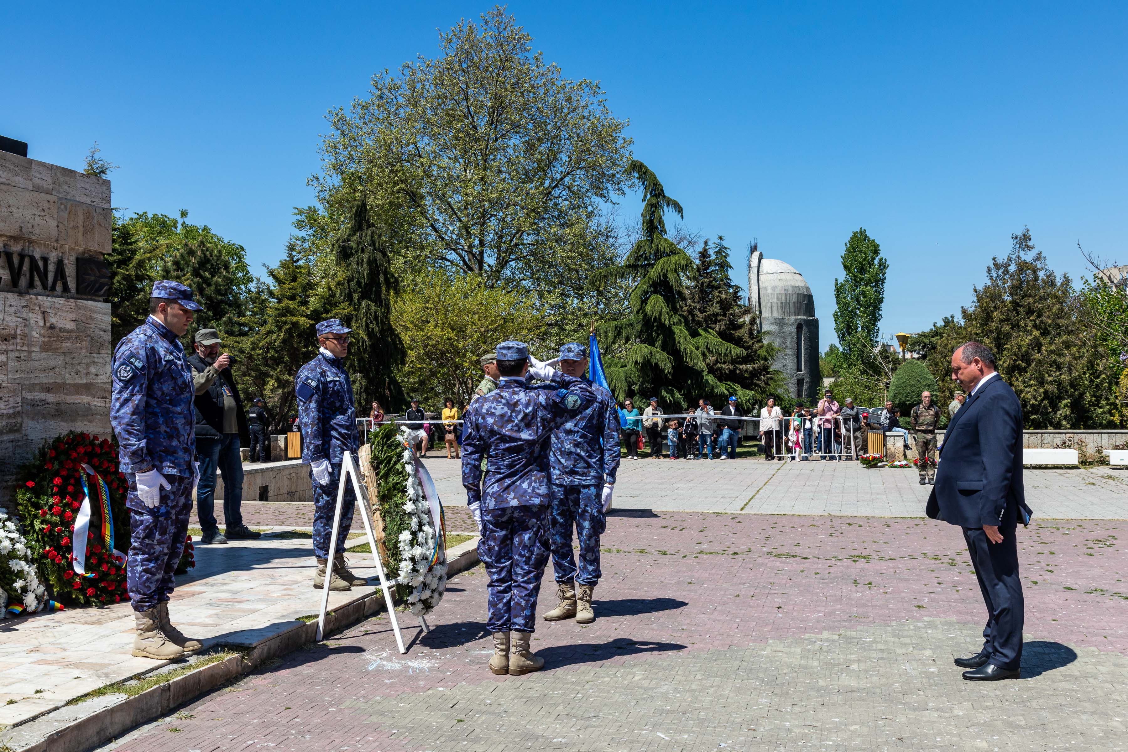 Romanian personnel salute at ceremony.