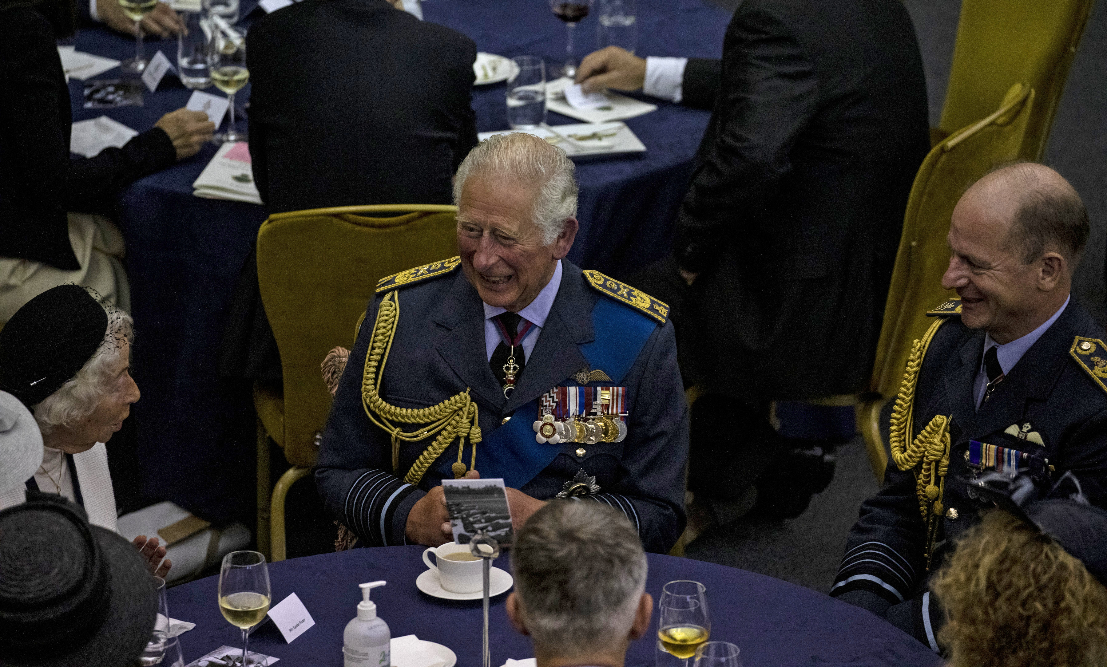 His Royal Highness sits at a table with Air Chief Marshal Mike Wigston and others.