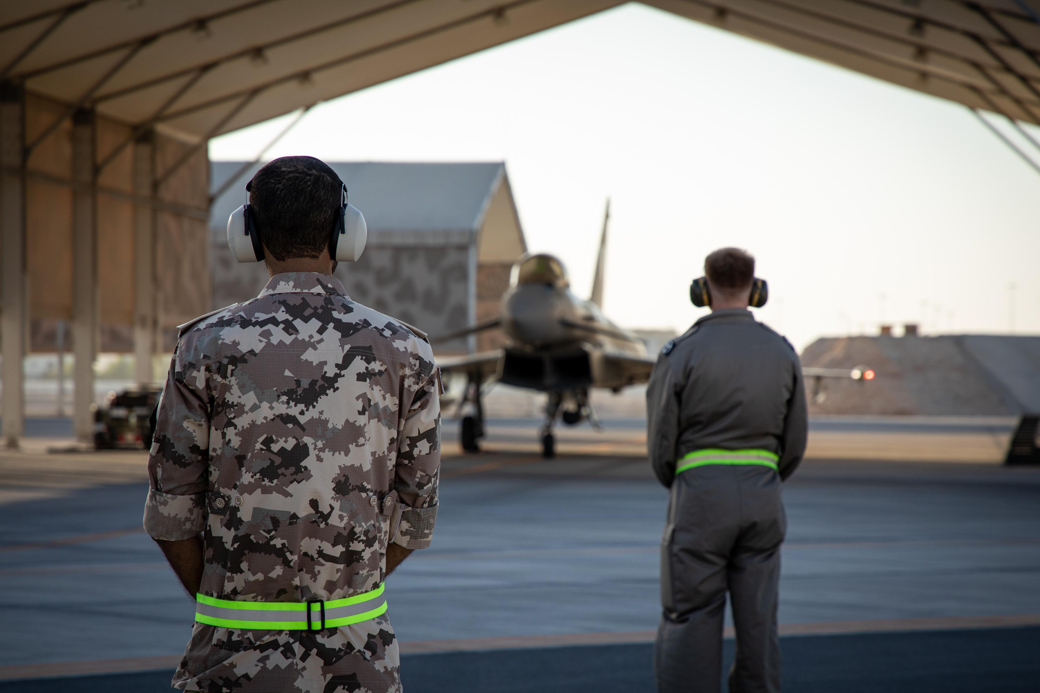 Personnel look towards Typhoons under hangar.