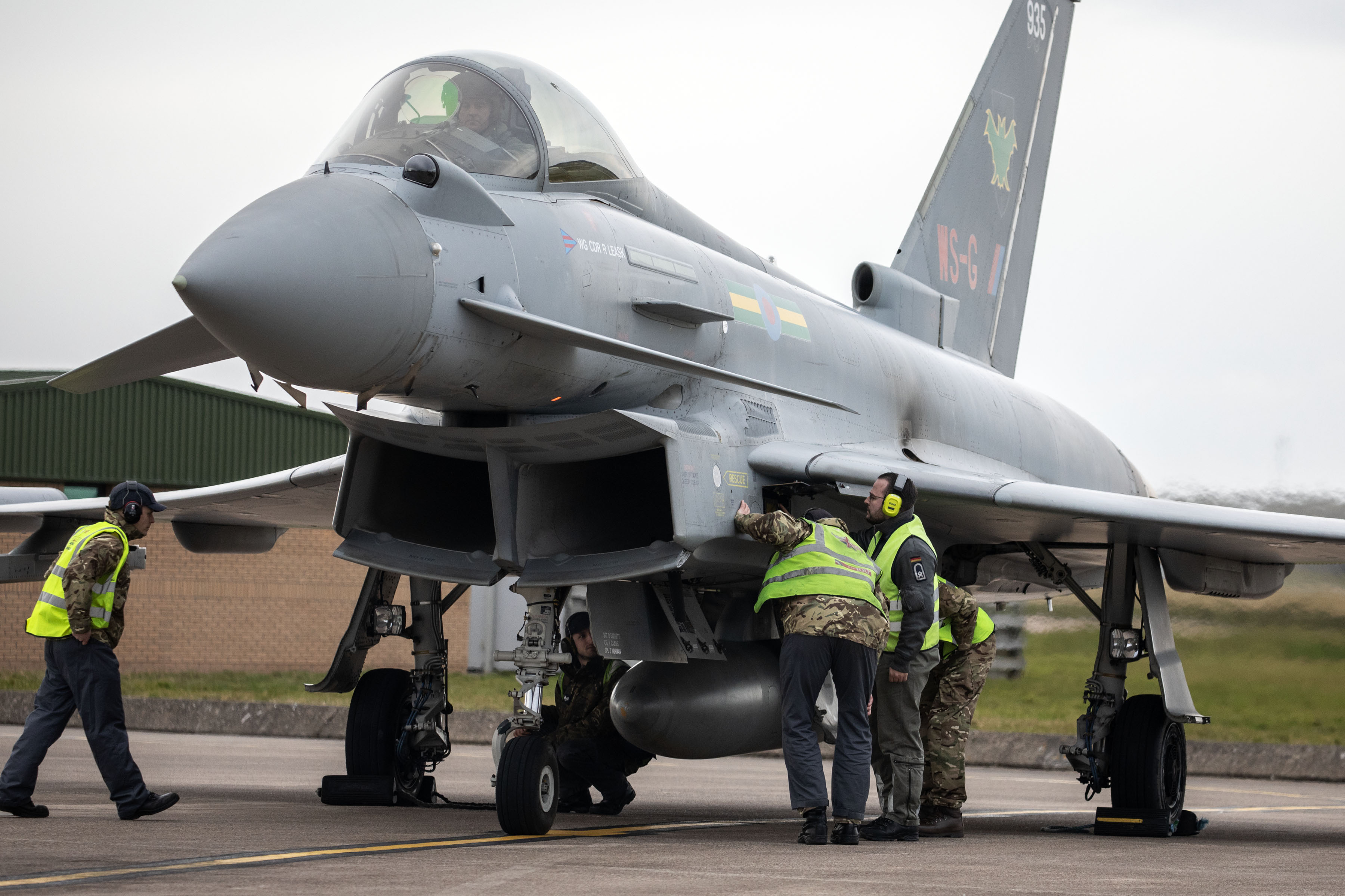 Image shows RAF aviators inspecting a Typhoon on the airfield.