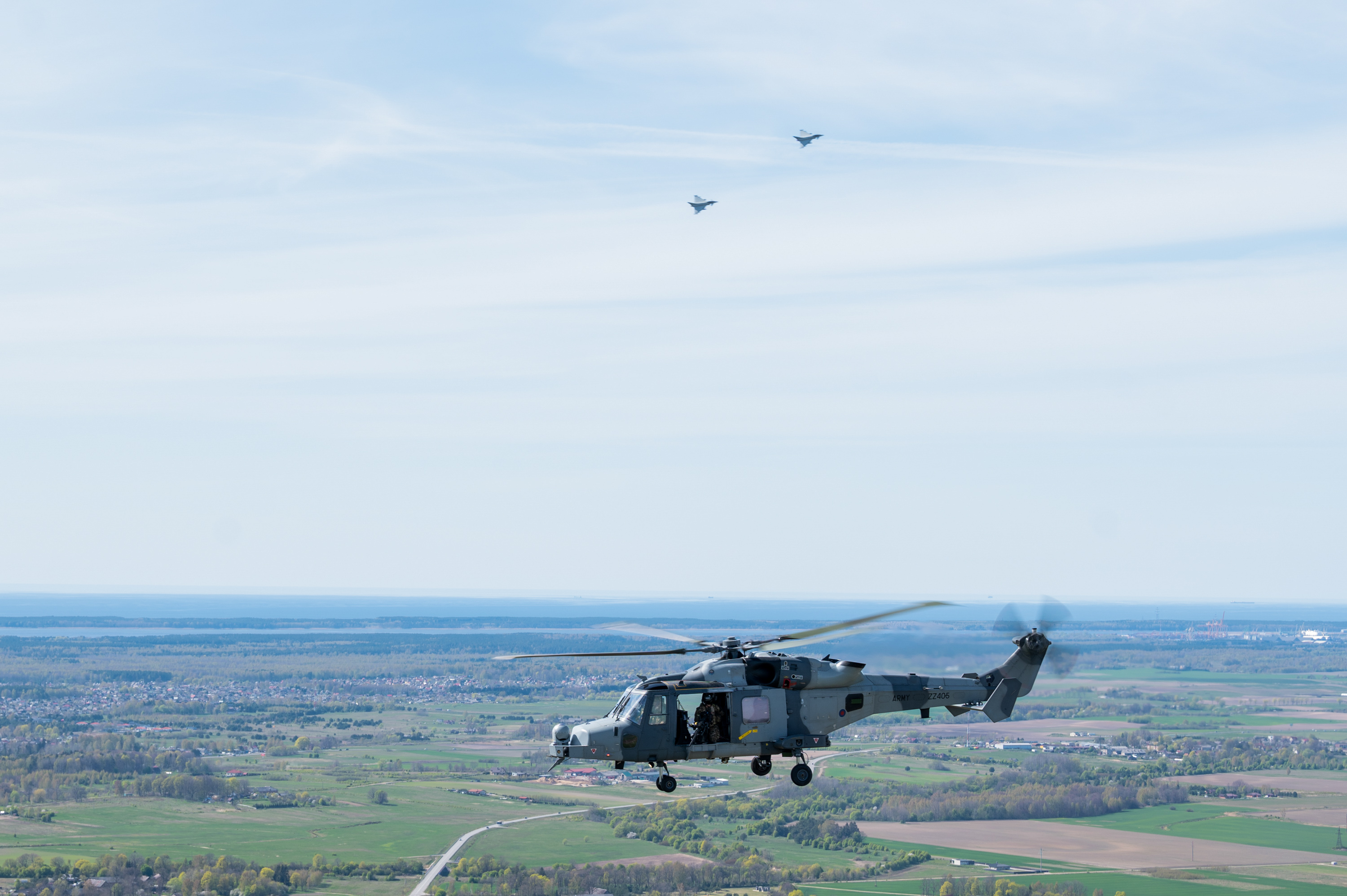 Two RAF Typhoons and a British Army Wildcat helicopter in flight.