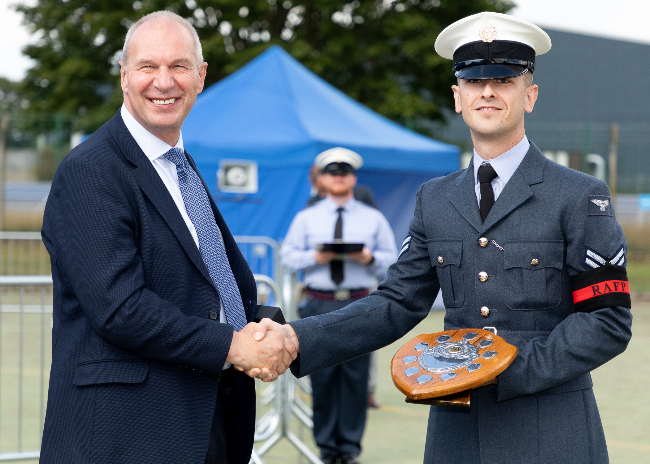RAF Police Handler shakes hands while being awarded trophy.