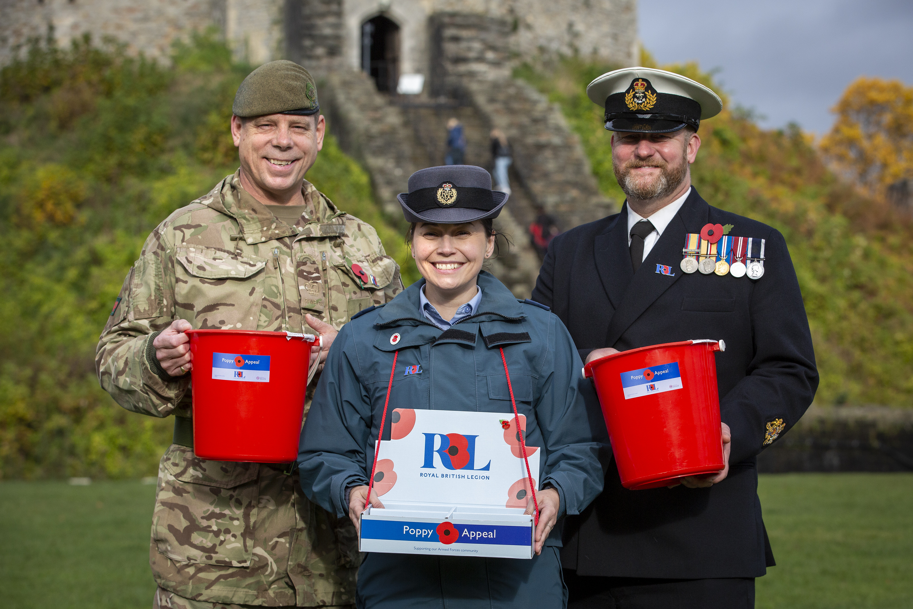 Personnel stand outside with Poppy bucket collections. 