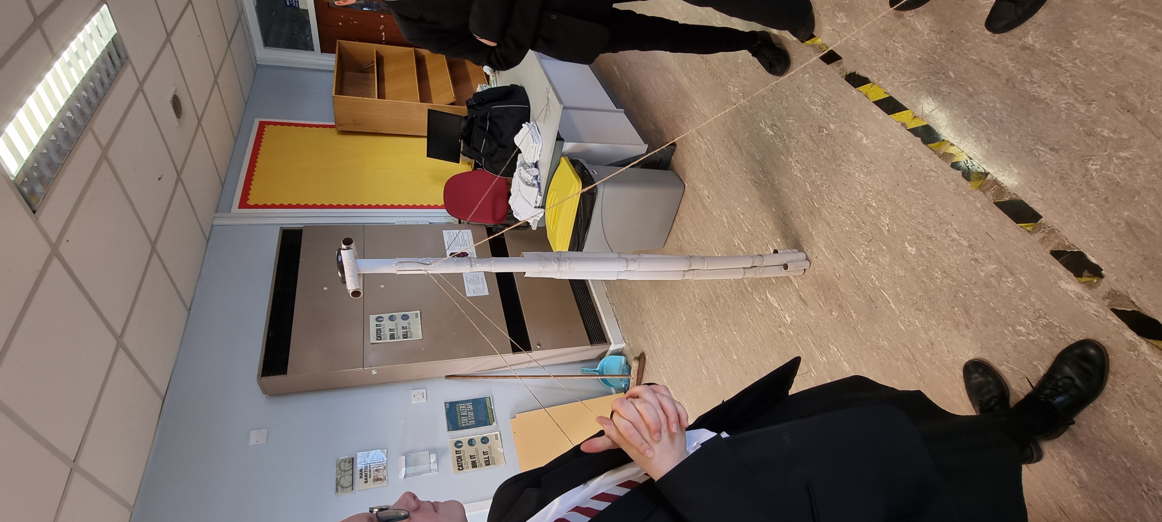 Students stand by model made from toilet rolls.