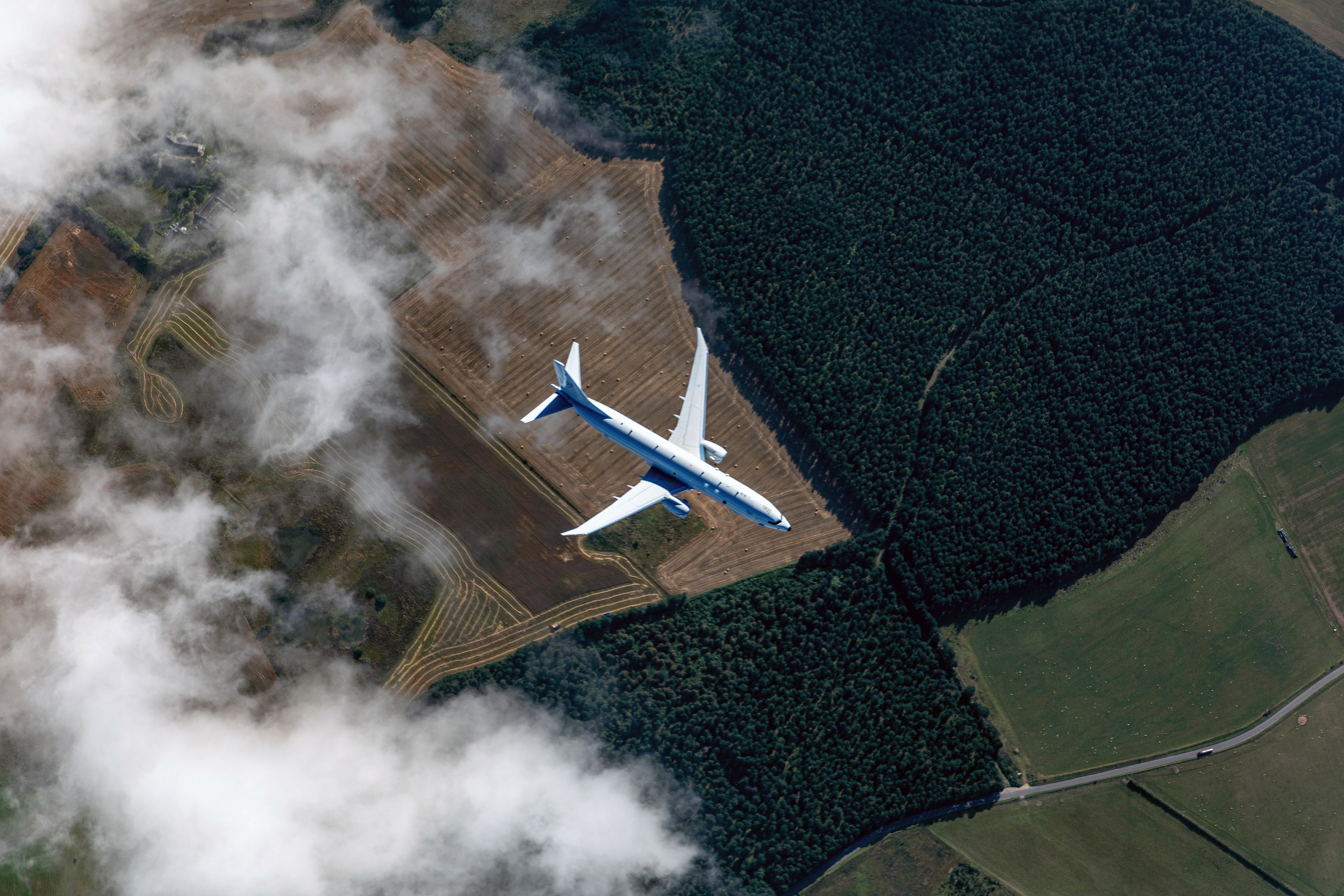 Poseidon aircraft flying through clouds.