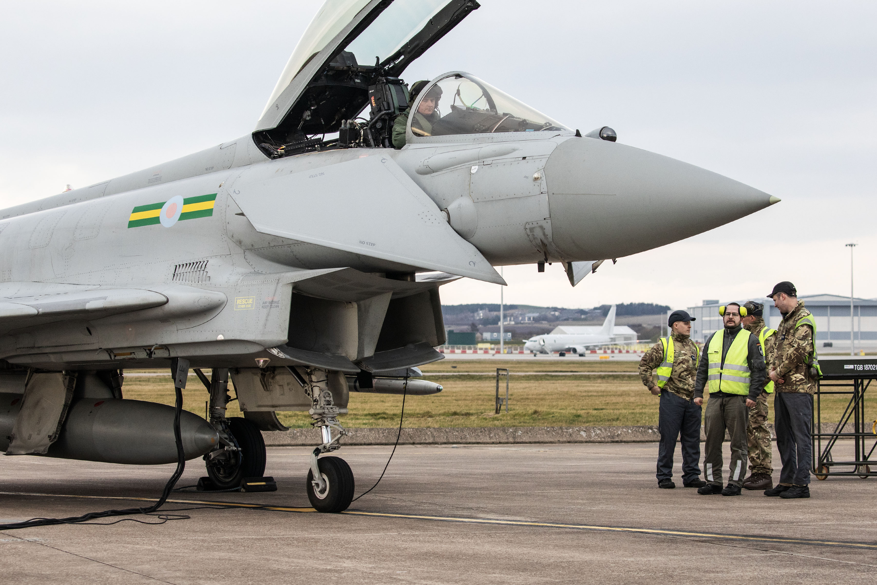 Image shows RAF aviators standing by a Typhoon with its cockpit open on the airfield.