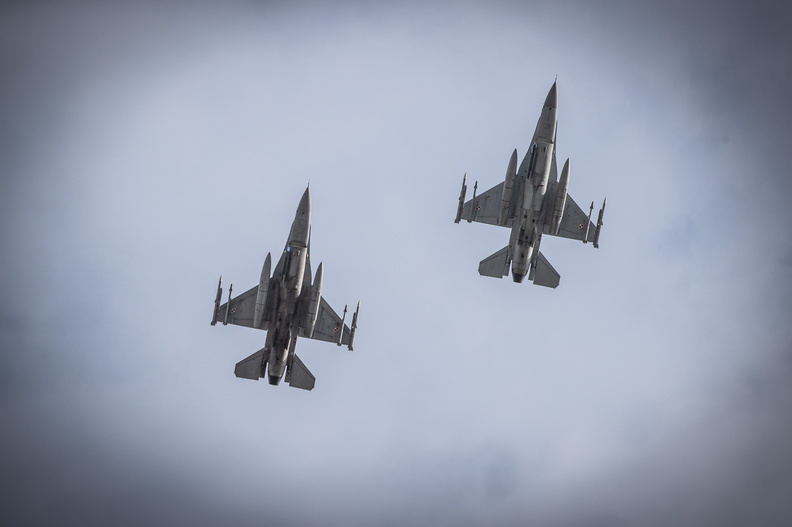 Shot of two F-16s in flight from below. 