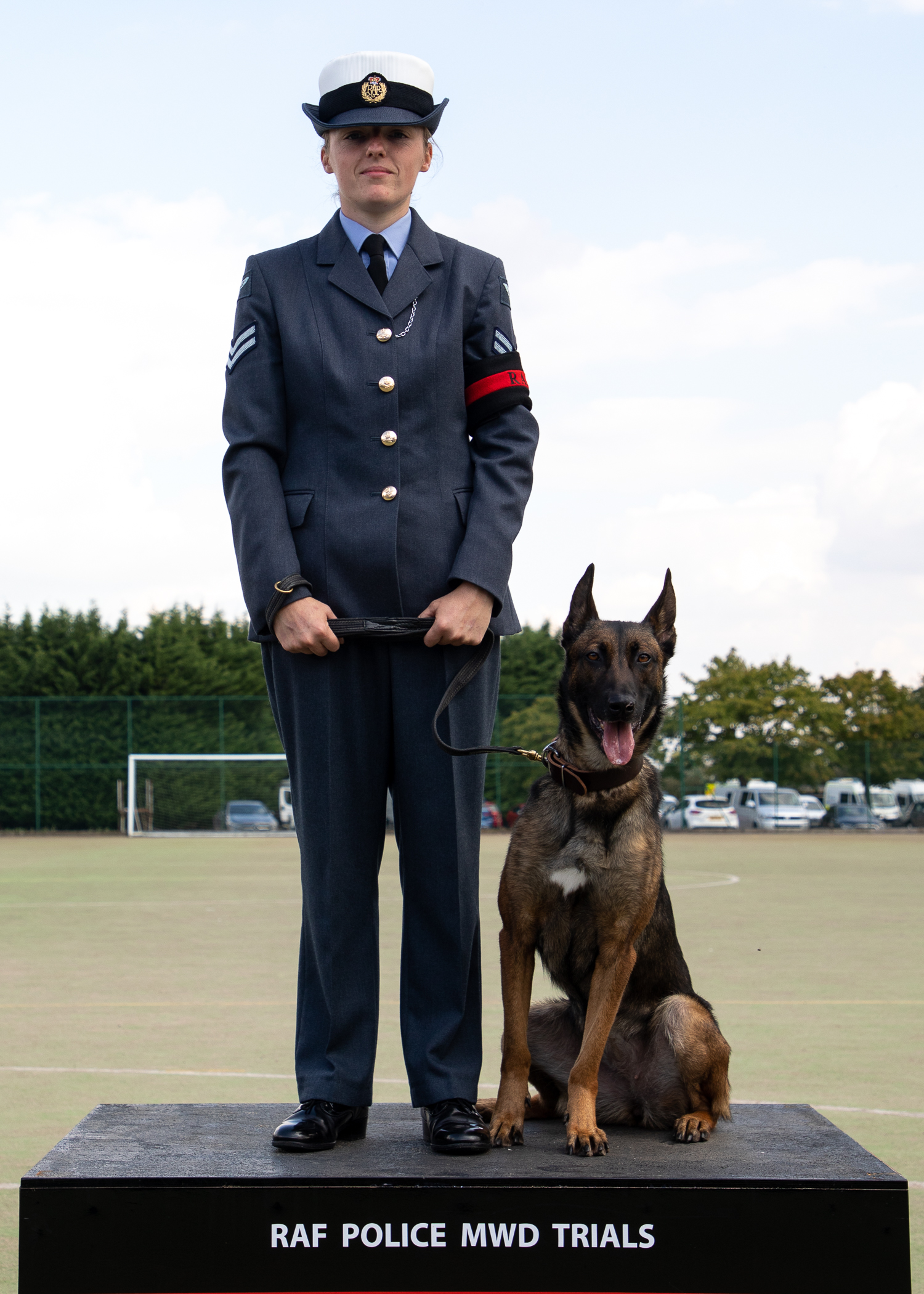 RAF Police Handler and dog stand on podium. 