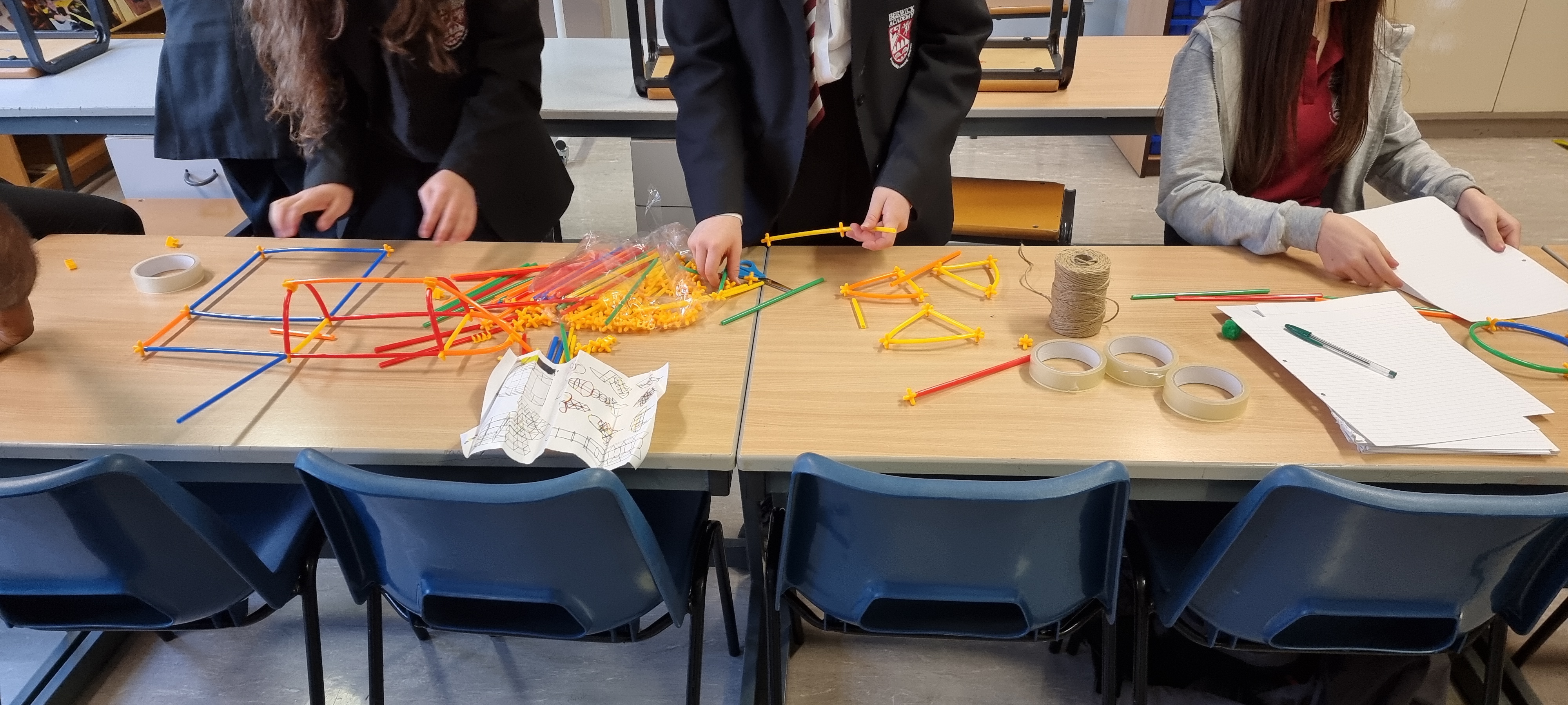 Students make models on classroom tables.
