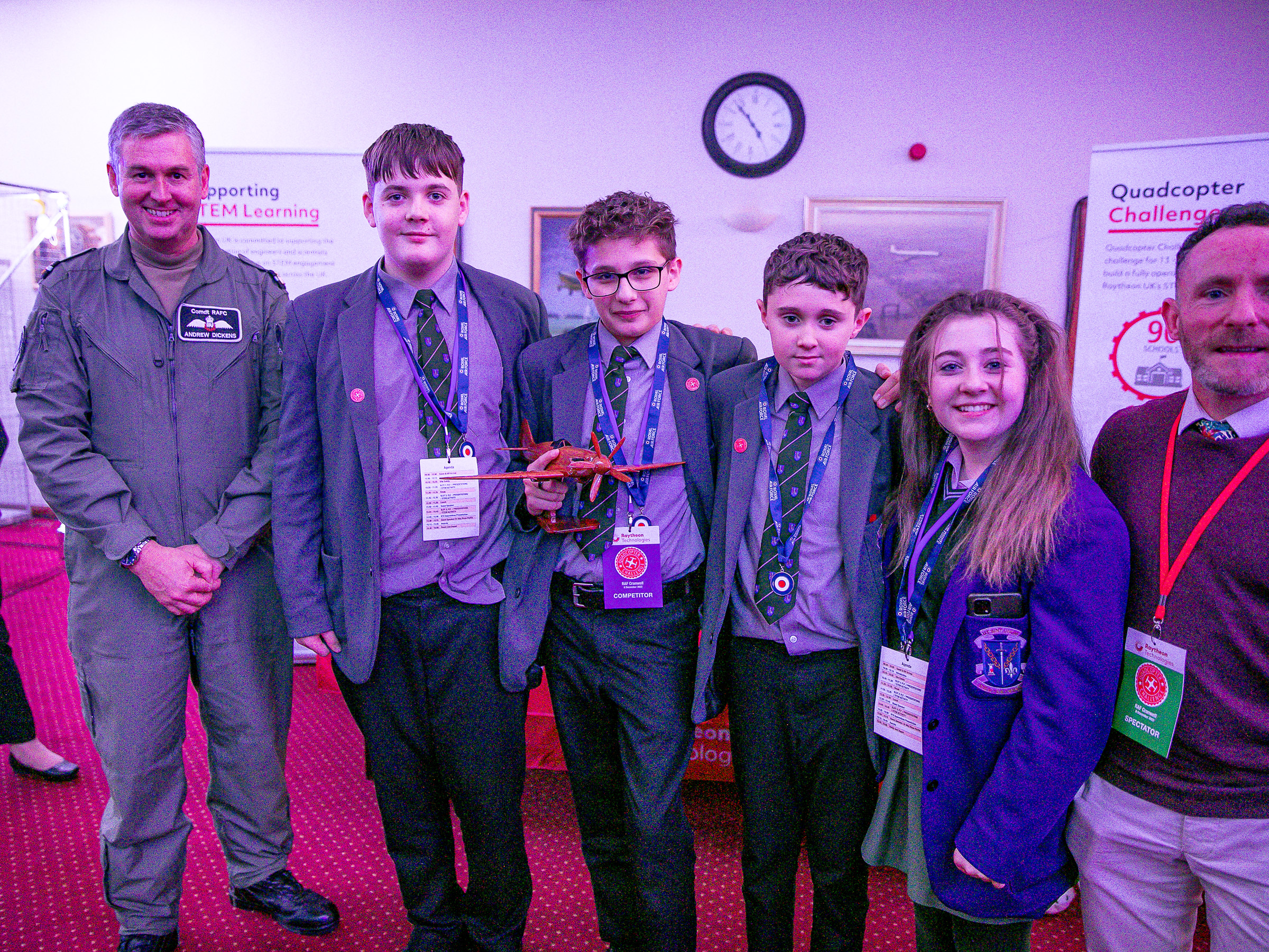 Image shows RAF pilots, civilians and school students with one holding a spitfire model award.