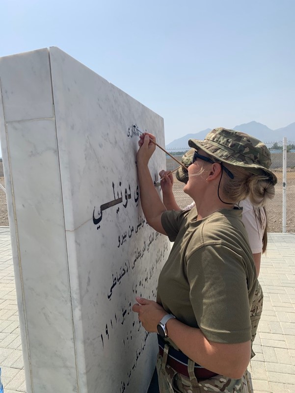 Personnel paint memorial lettering in Arabic.