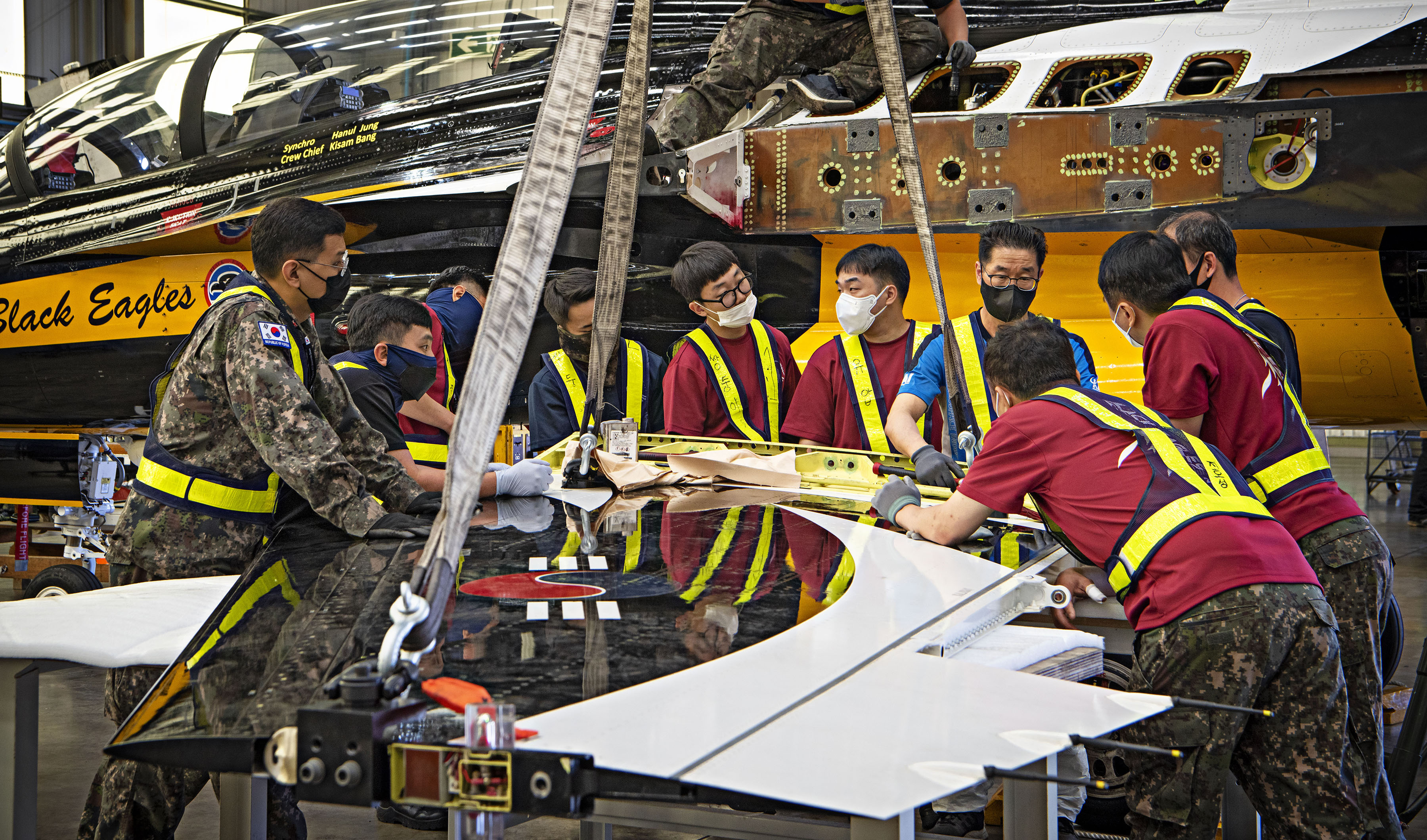 Image shows Korean Air Force Pilots working on Black Eagle aircraft parts.