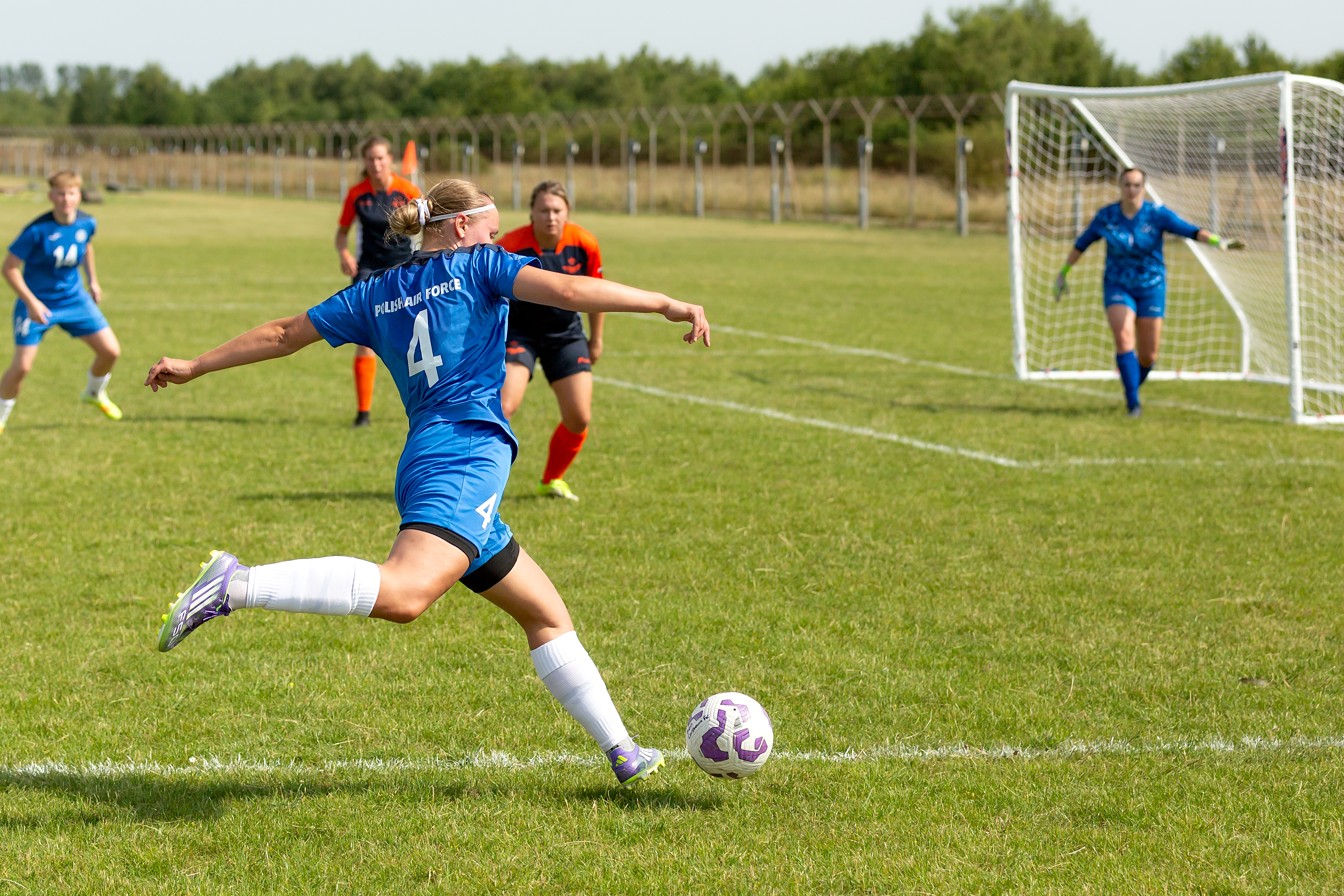 A Polish Air Force service person shooting a ball during a football match.