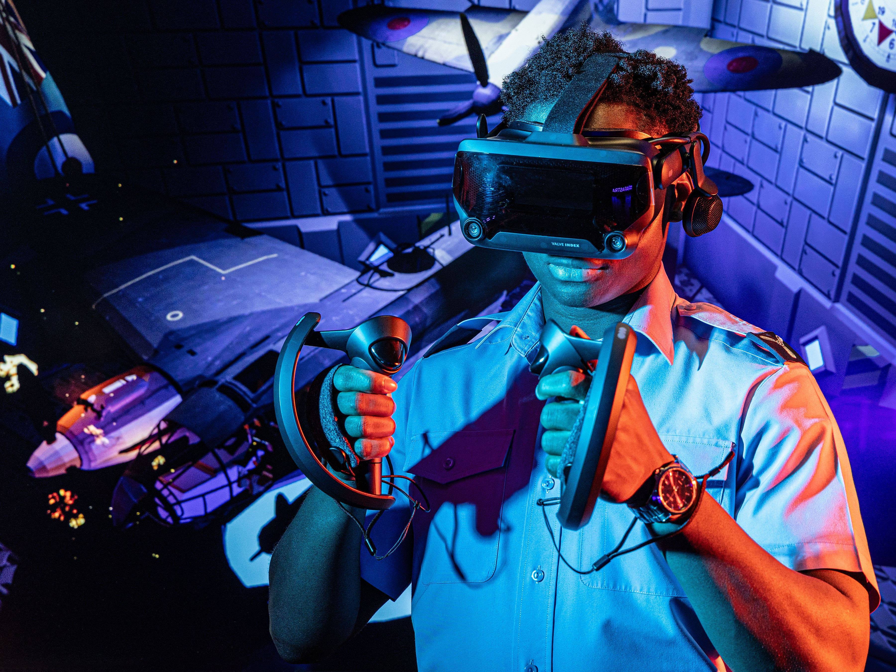RAF personnel using virtual reality headset against a blue background of space and aircraft