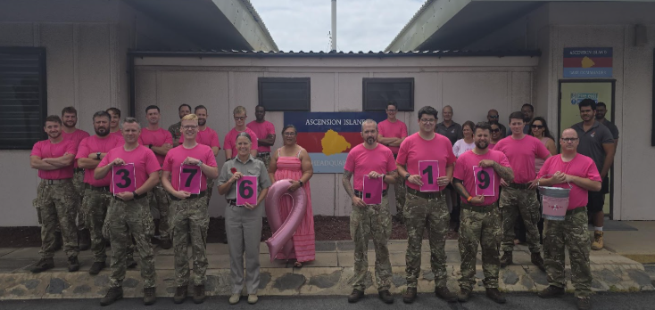 Picture shows CAIB and other personnel wearing pink t-shirts and displaying the amount of money they raised