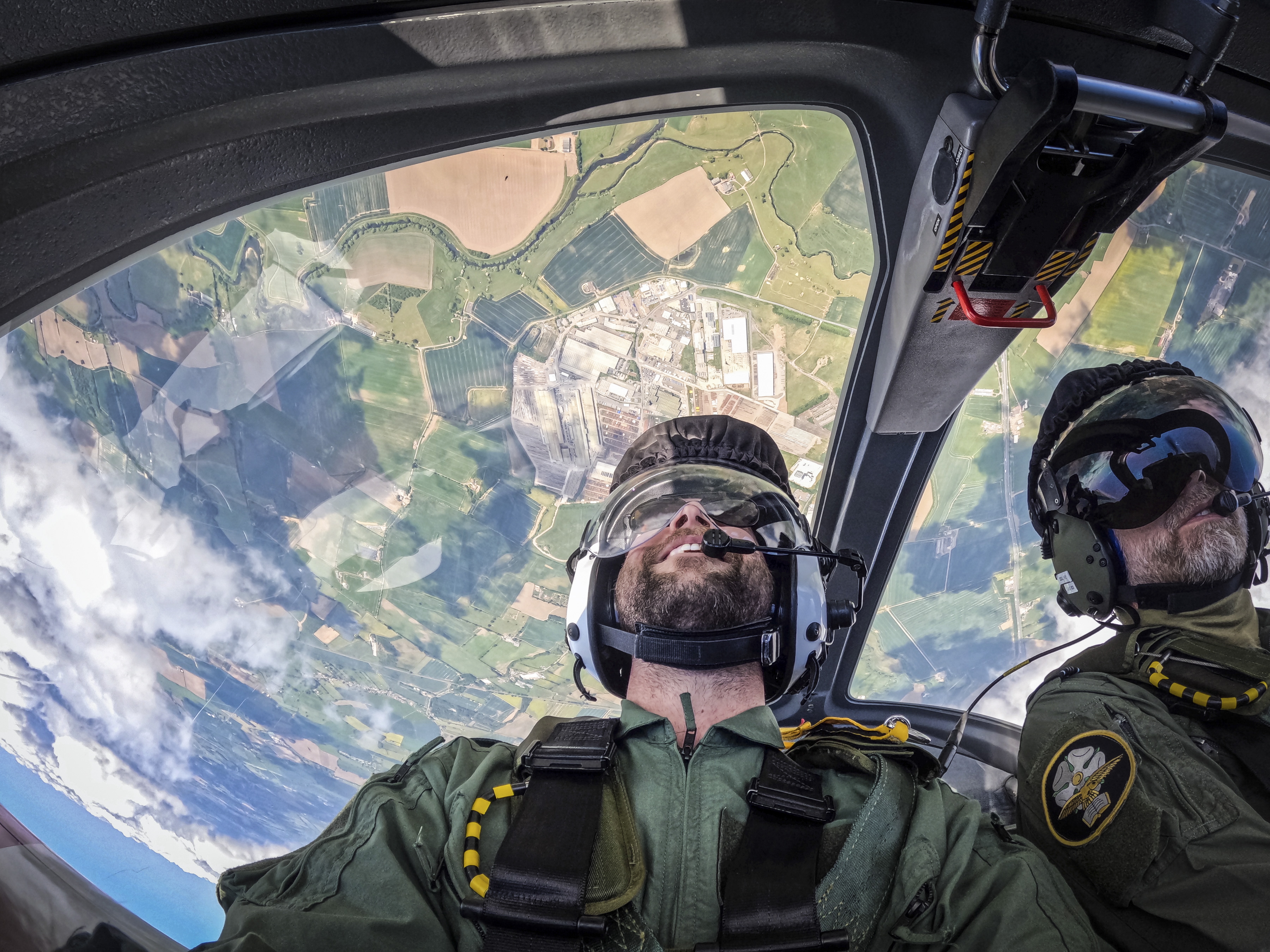 Pilots flying upside down over the countryside.