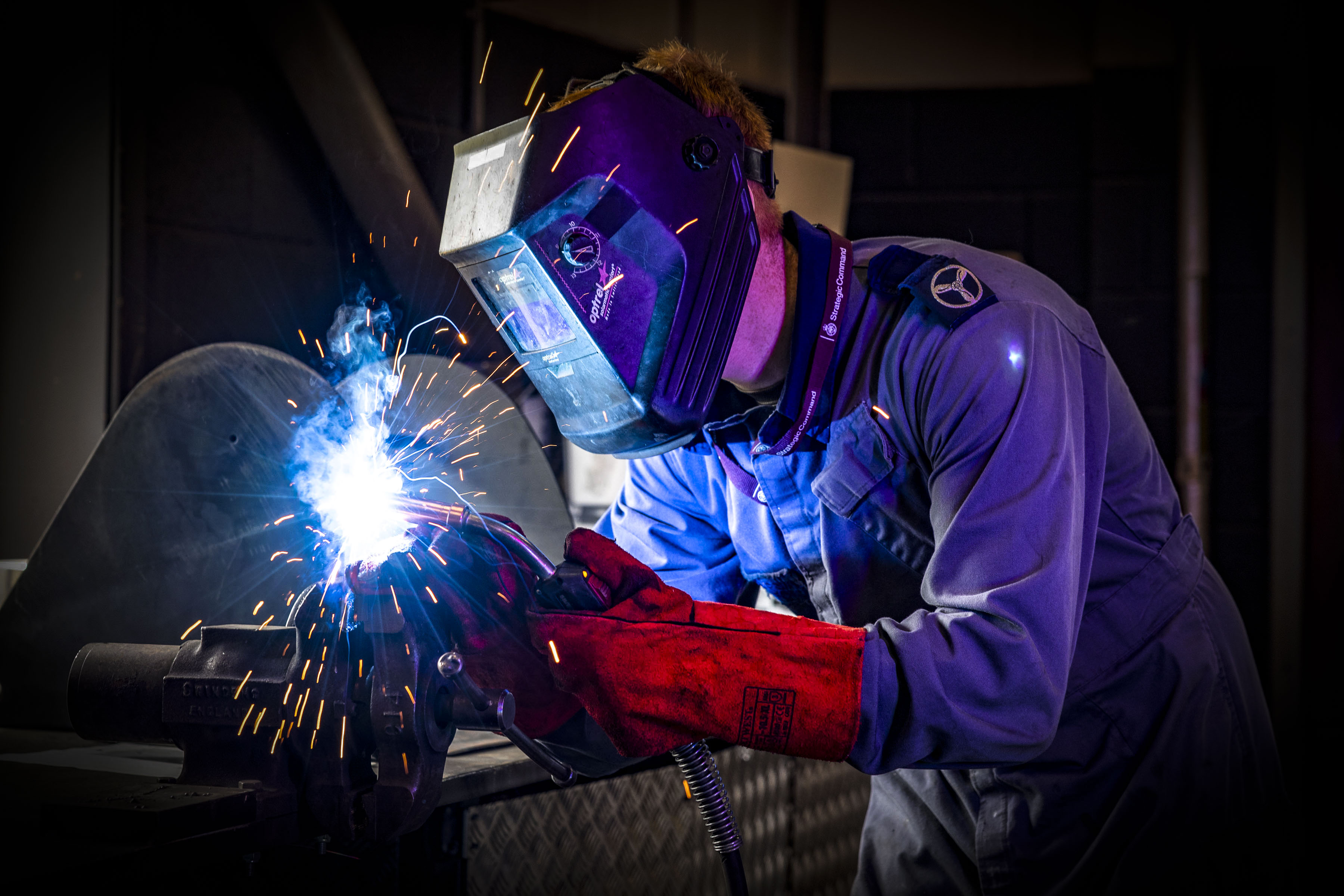 "Sparks". An Air Specialist Technician at work welding. Sparks are reflected in their protective visor.