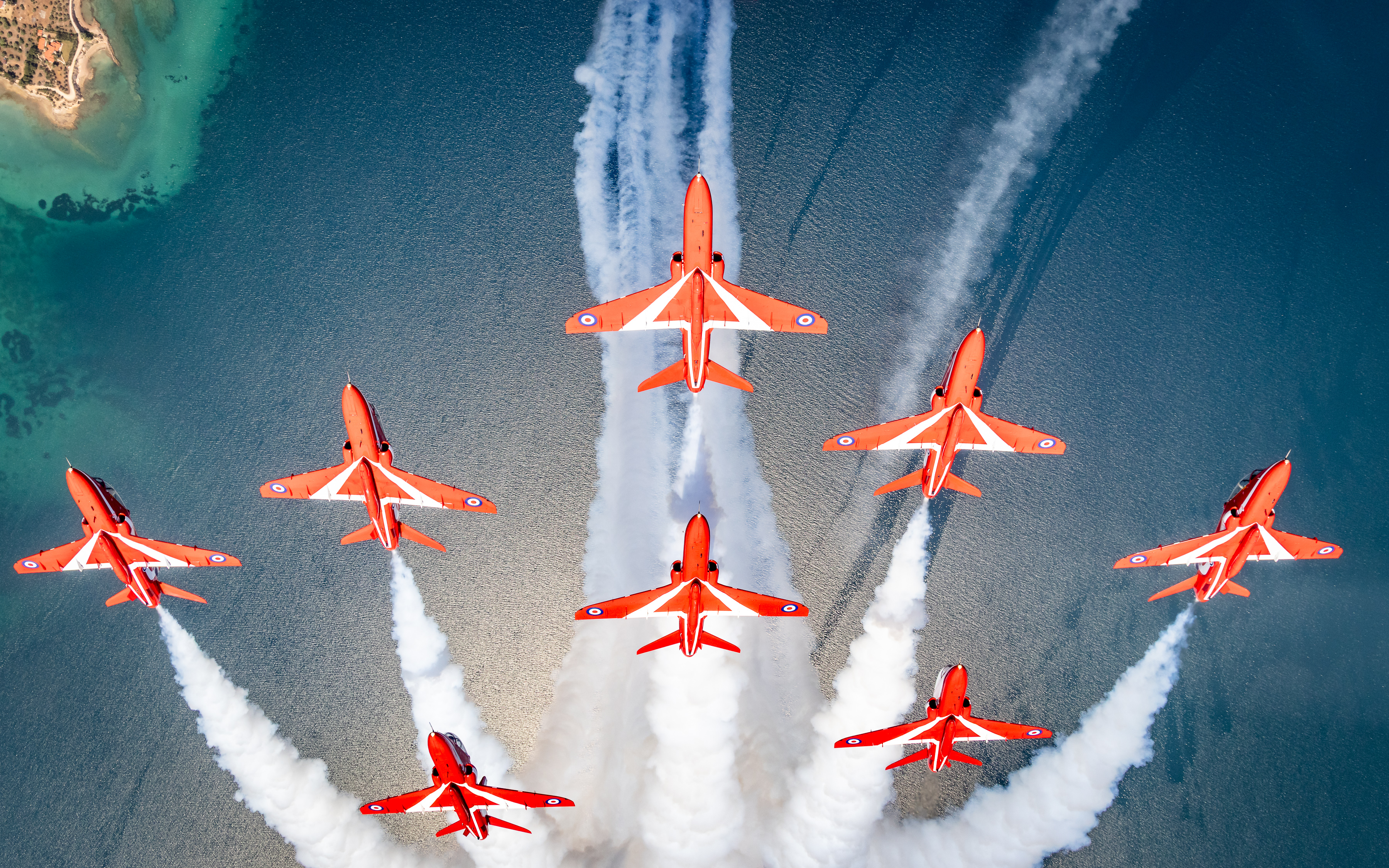 "Speed, Skill, Precision". Eight Hawk T1s of the Red Arrows fly in formation over the sea.