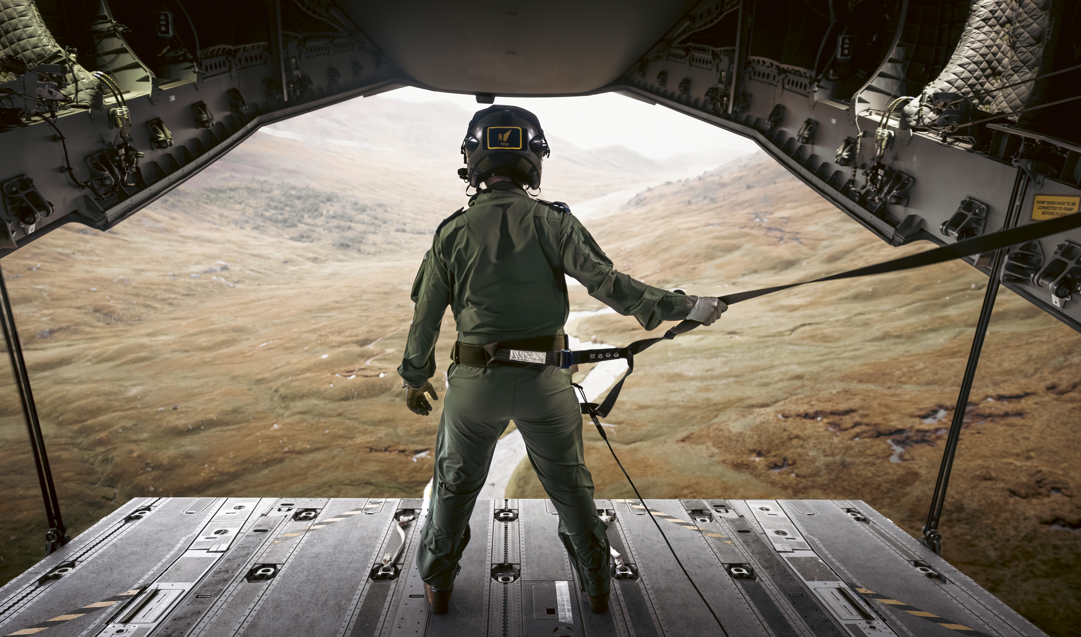 "The Office". An RAF aviator stands on an A400M's rear ramp as it is lowered. Out of the rear ramp, a sparse valley can be seen.