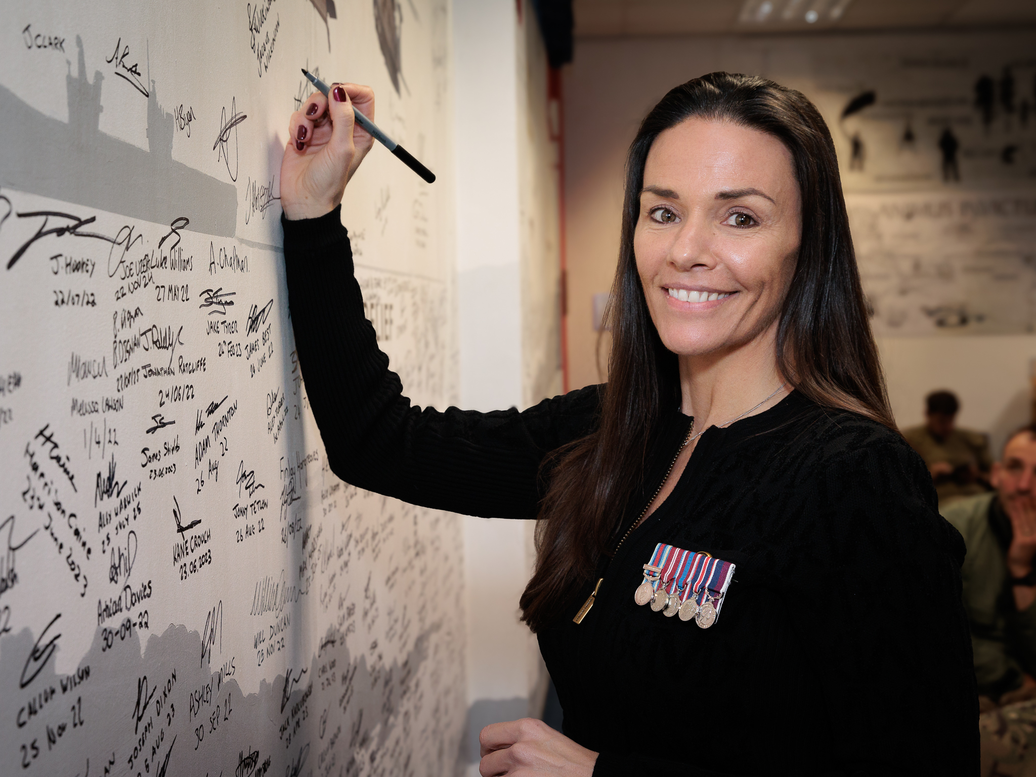 Wg Cdr Wiklinson signing the Wall of Honour