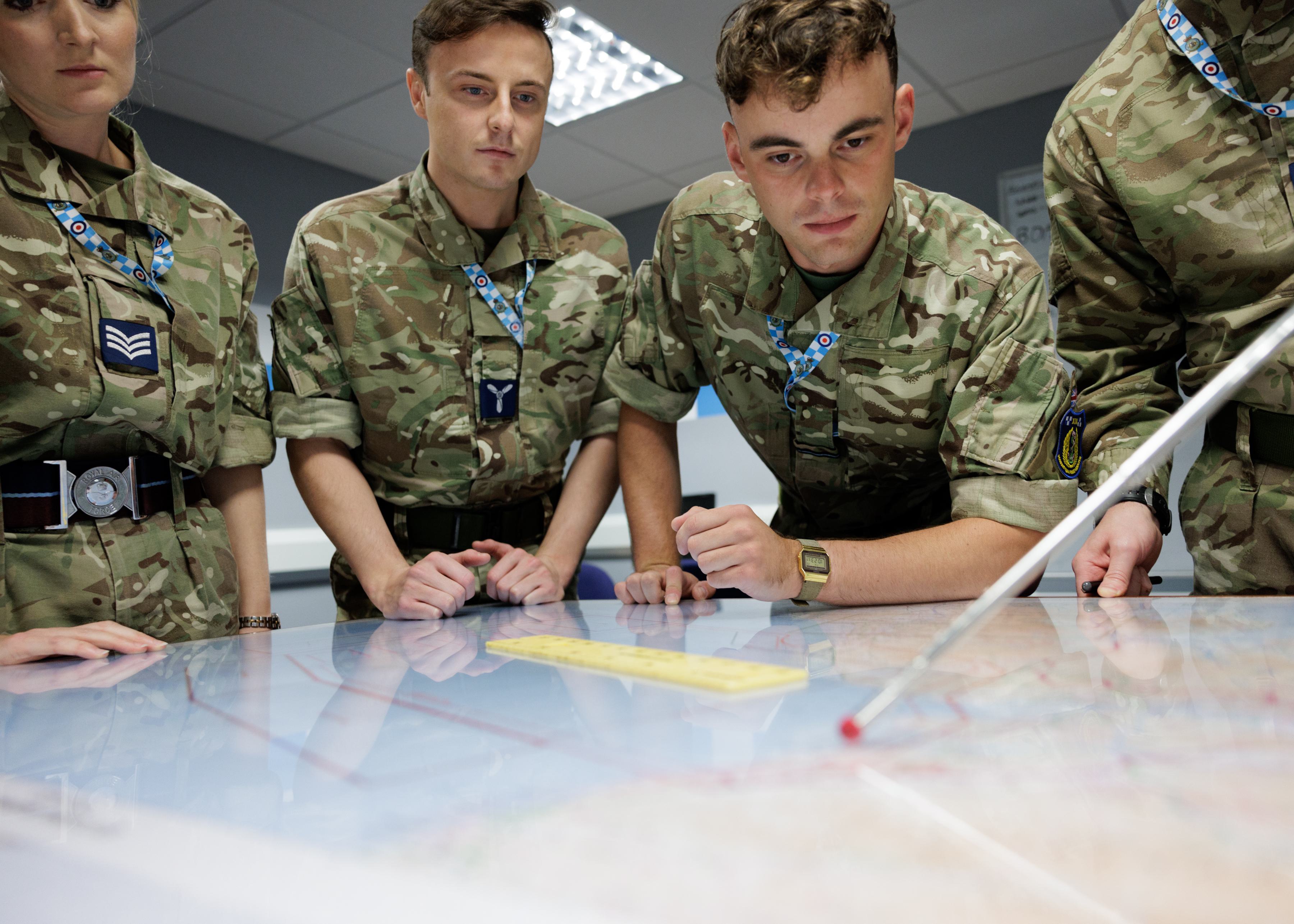 Personnel working and looking over a table.