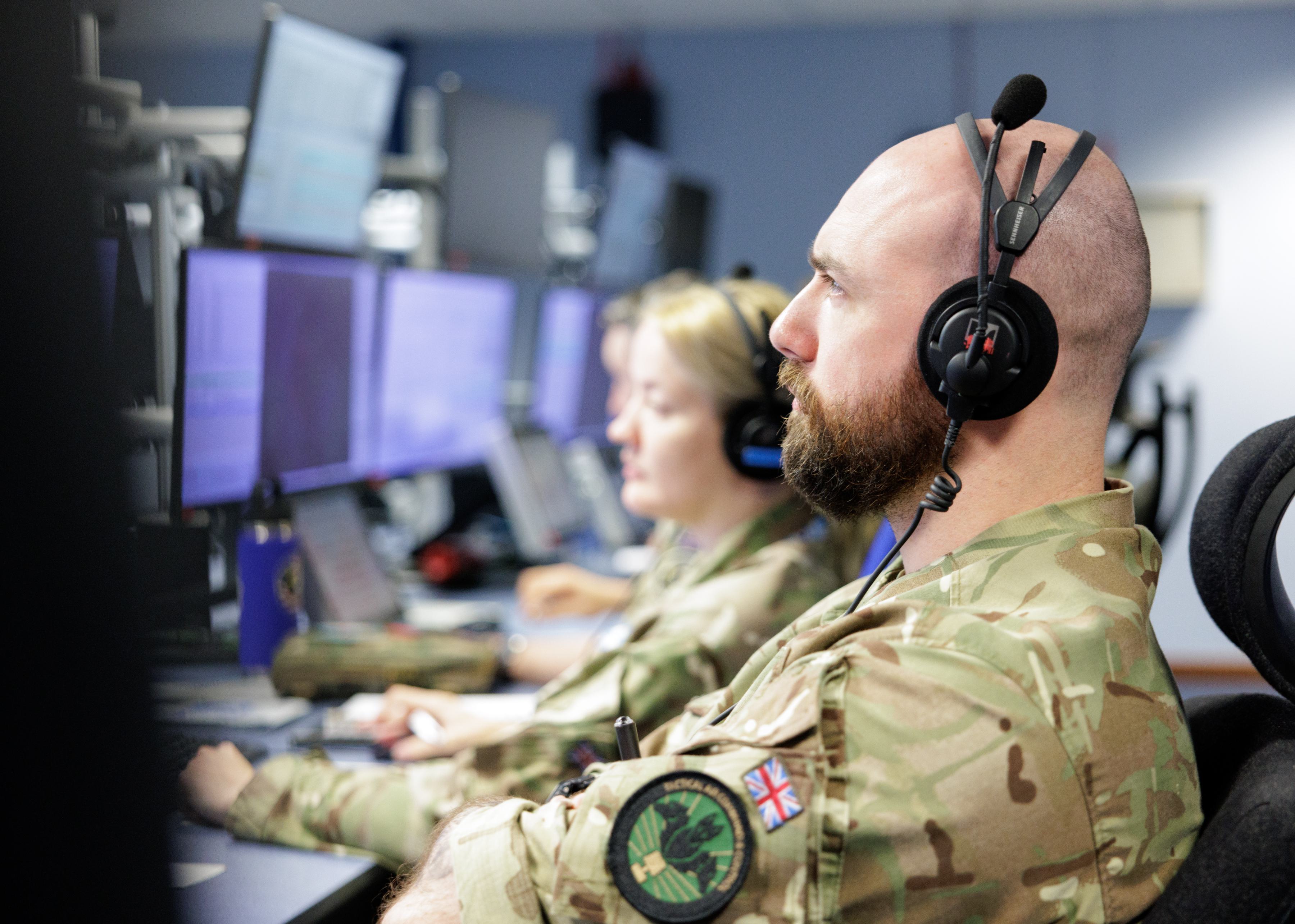 Personnel sitting and working at screens.