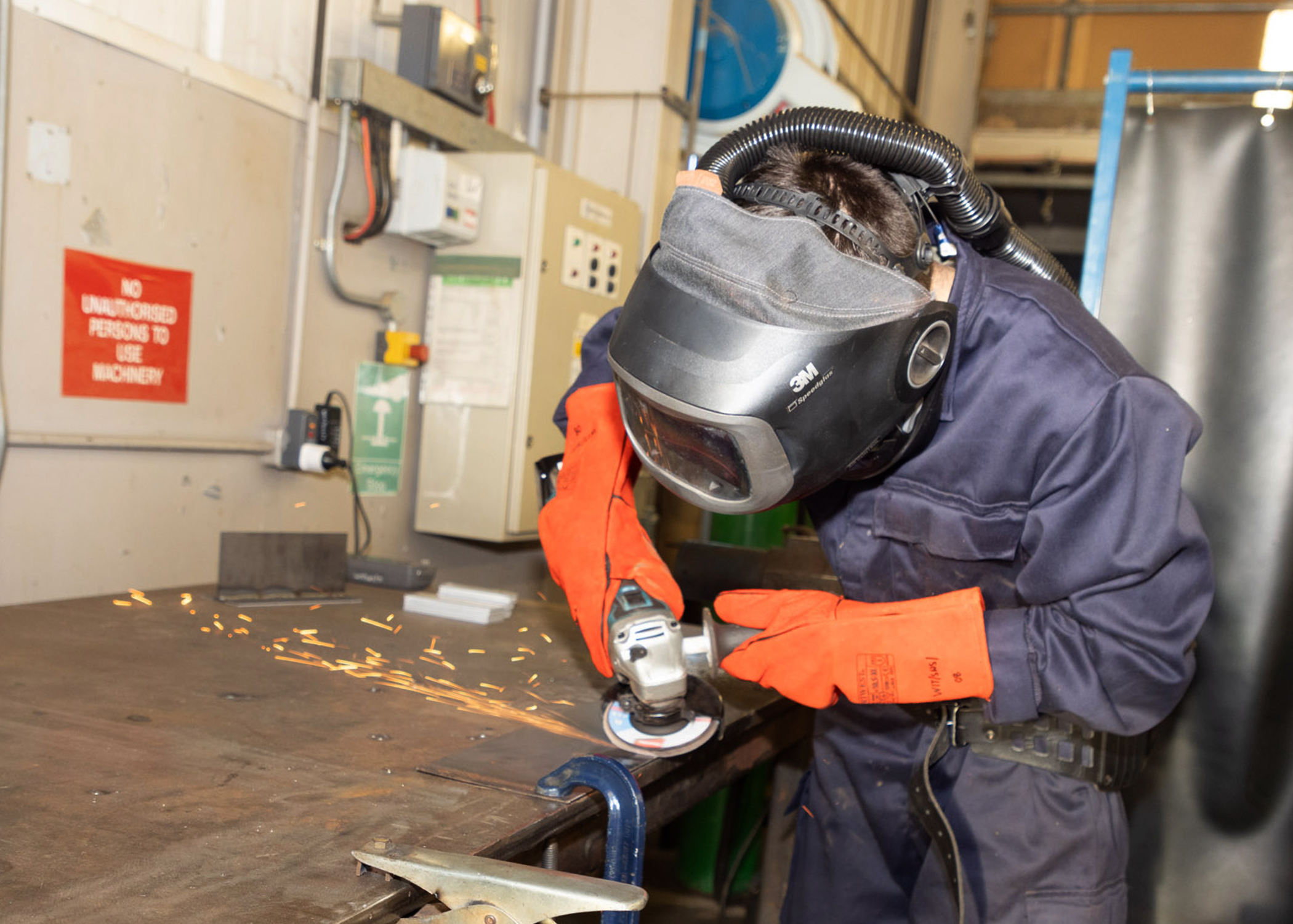 An RAF serviceperson using a grinder while wearing protective equipment.