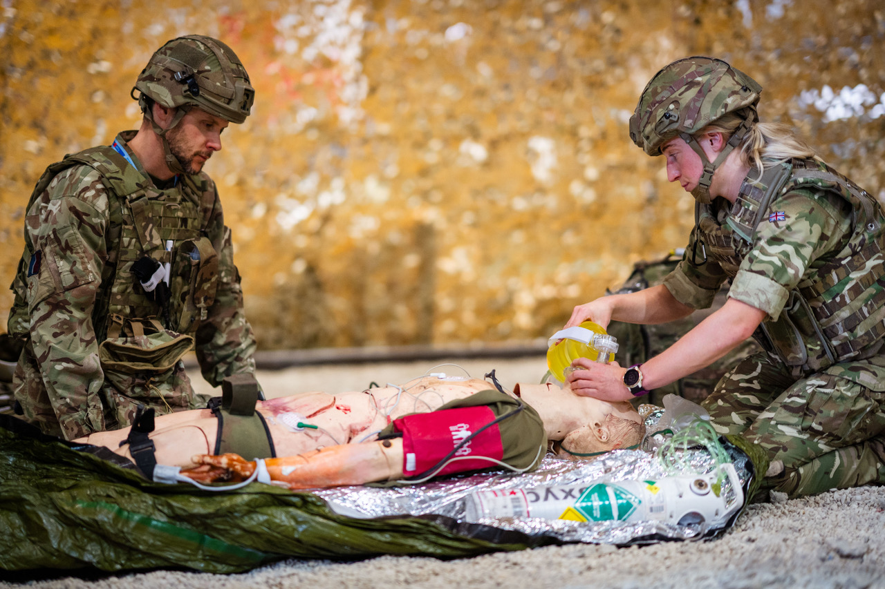 Two RAF medical personnel training on a medical dummy.
