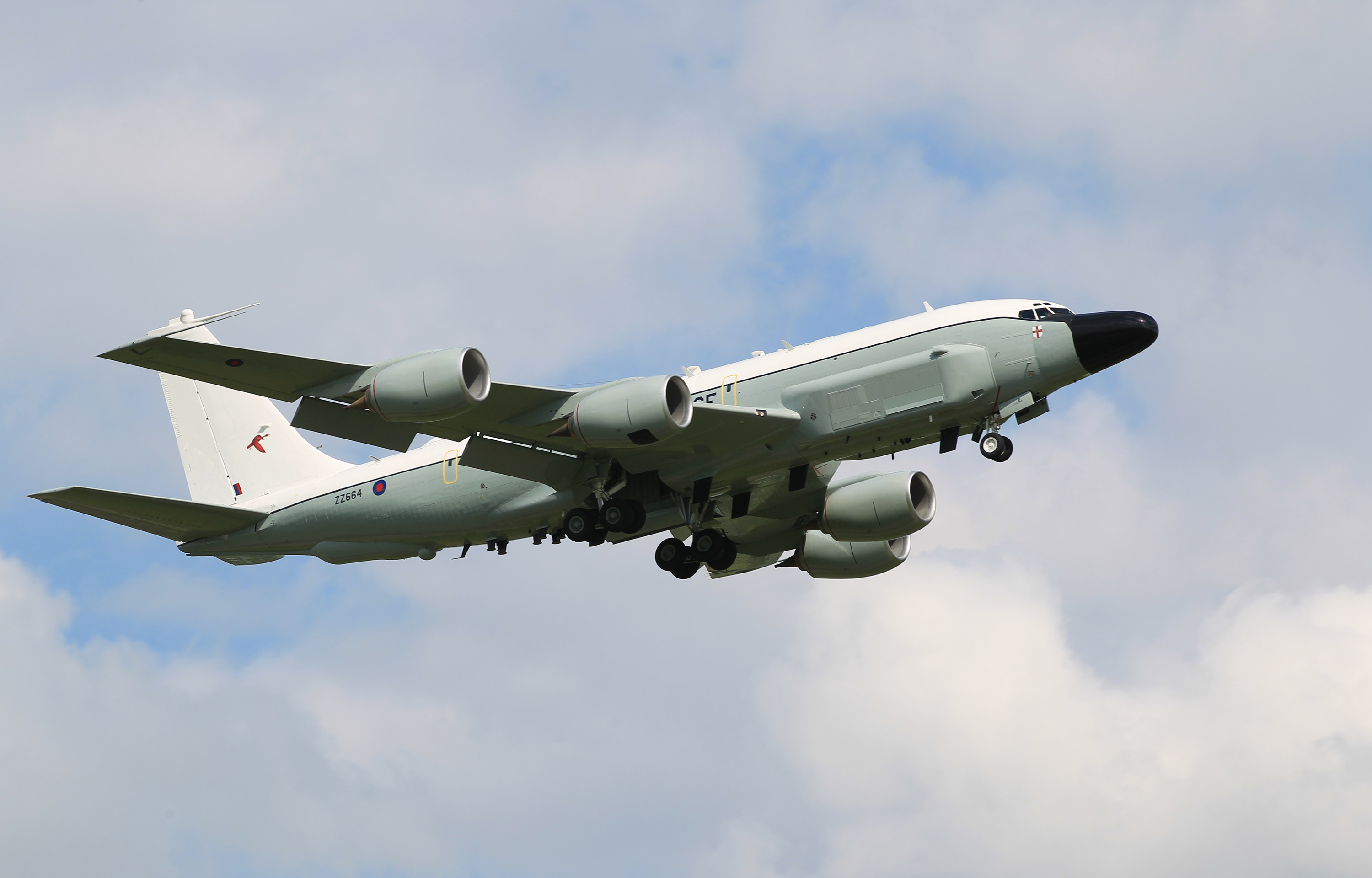 An RAF Rivet Joint mid-flight against a blue cloudy sky.