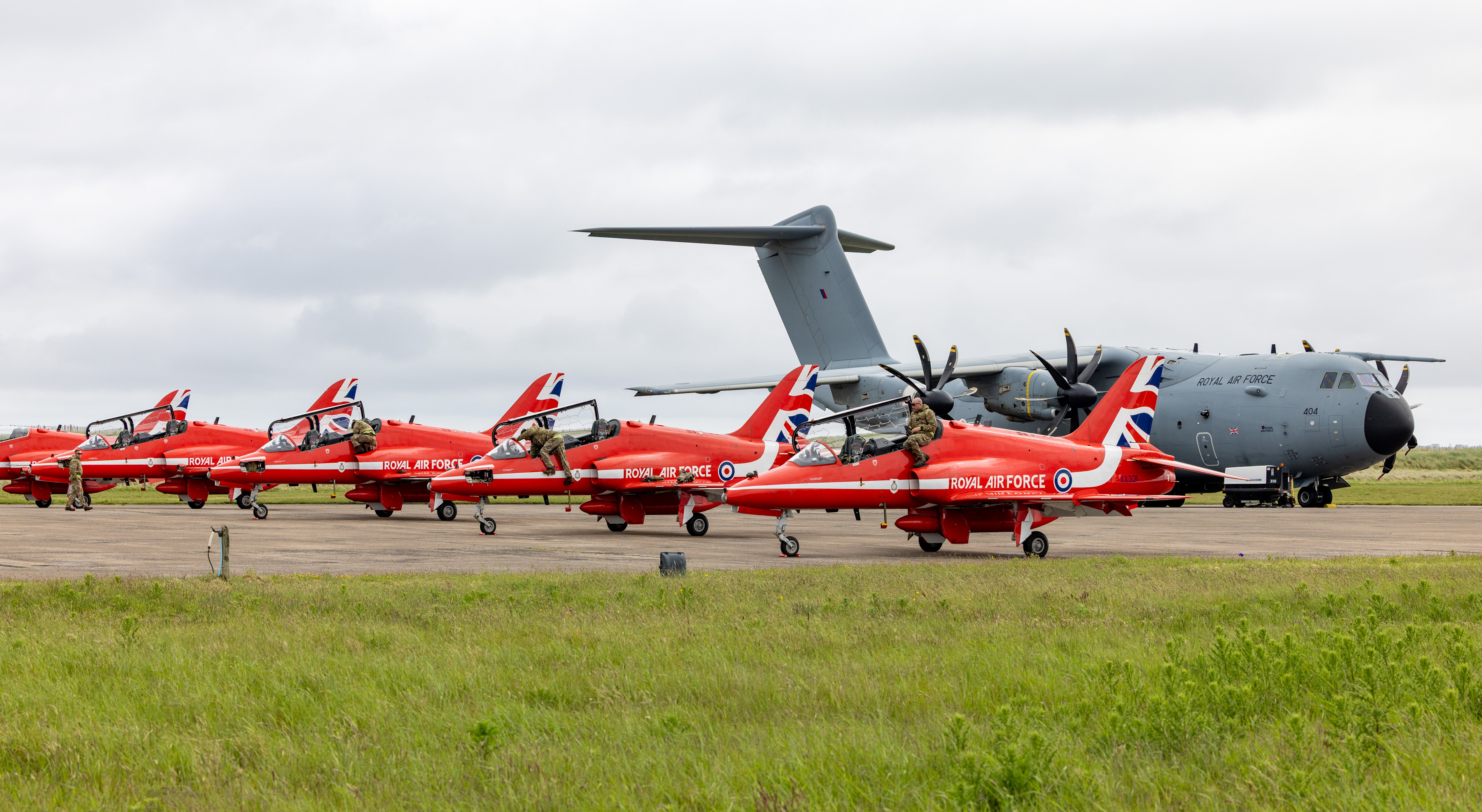 The Red Arrows parked in a row in front of an RAF A400M