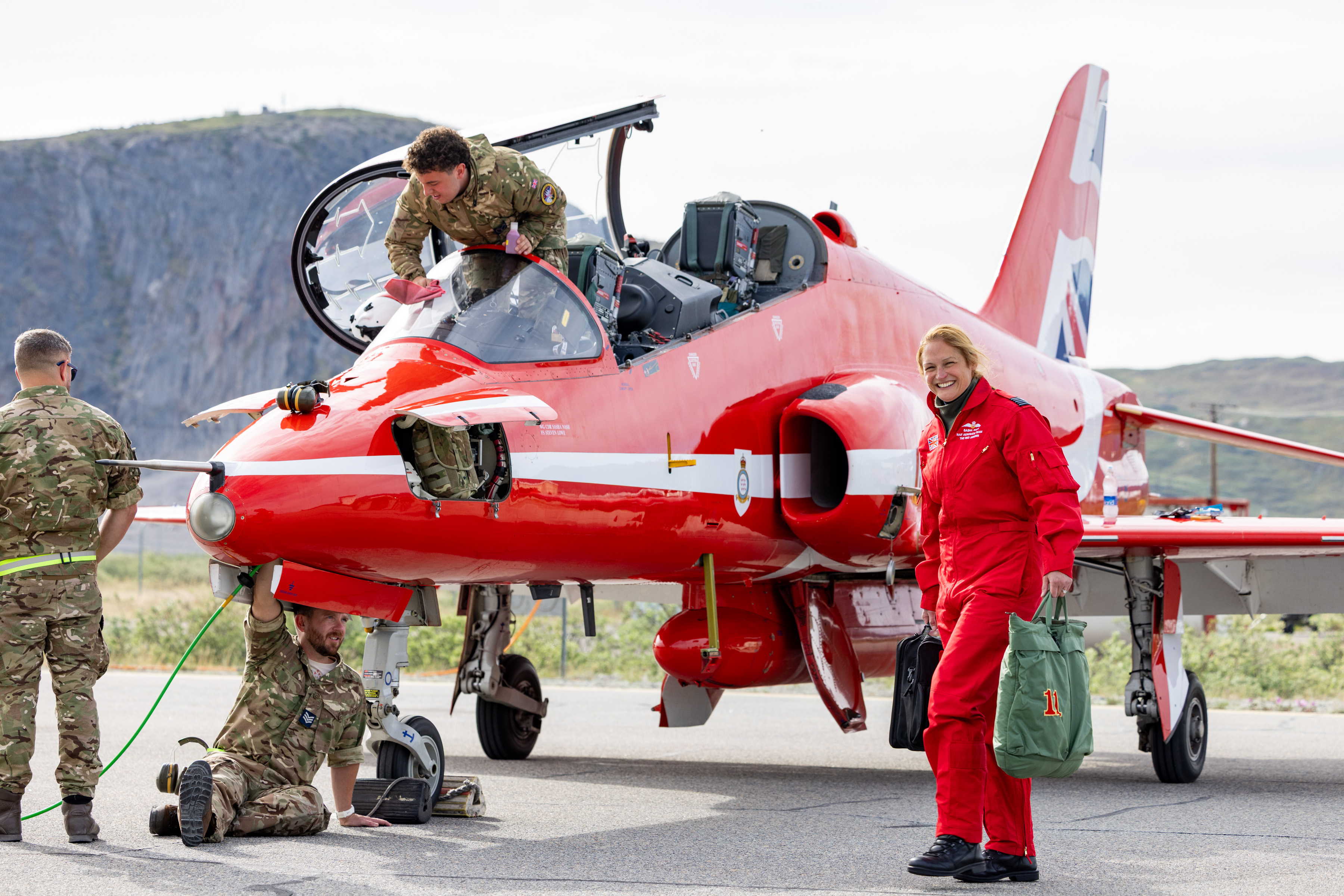A team of engineers from the Red Arrows working on a Hawk, with the Officer Commanding Sarah Nash in front.