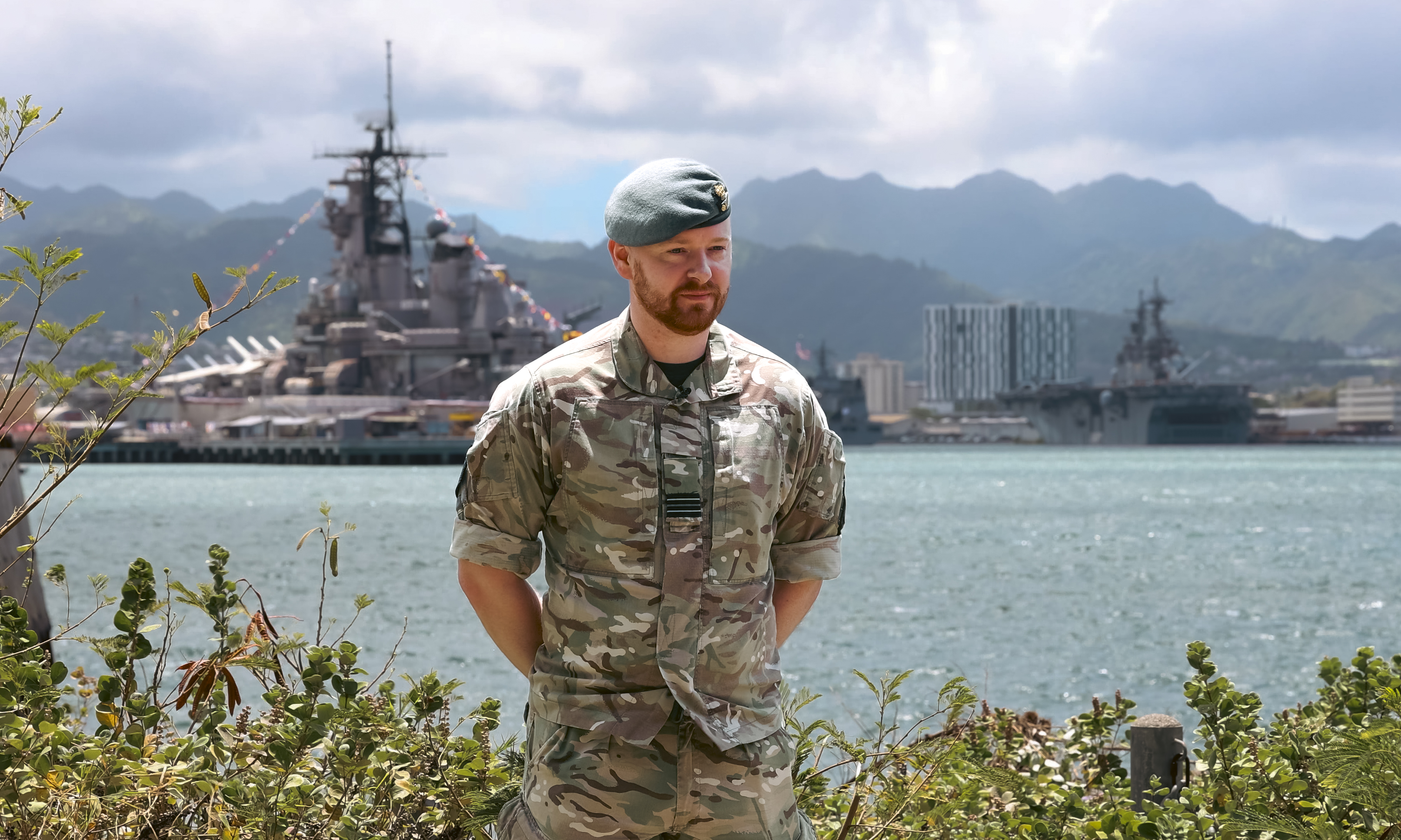 An RAF officer standing with a harbour in the background