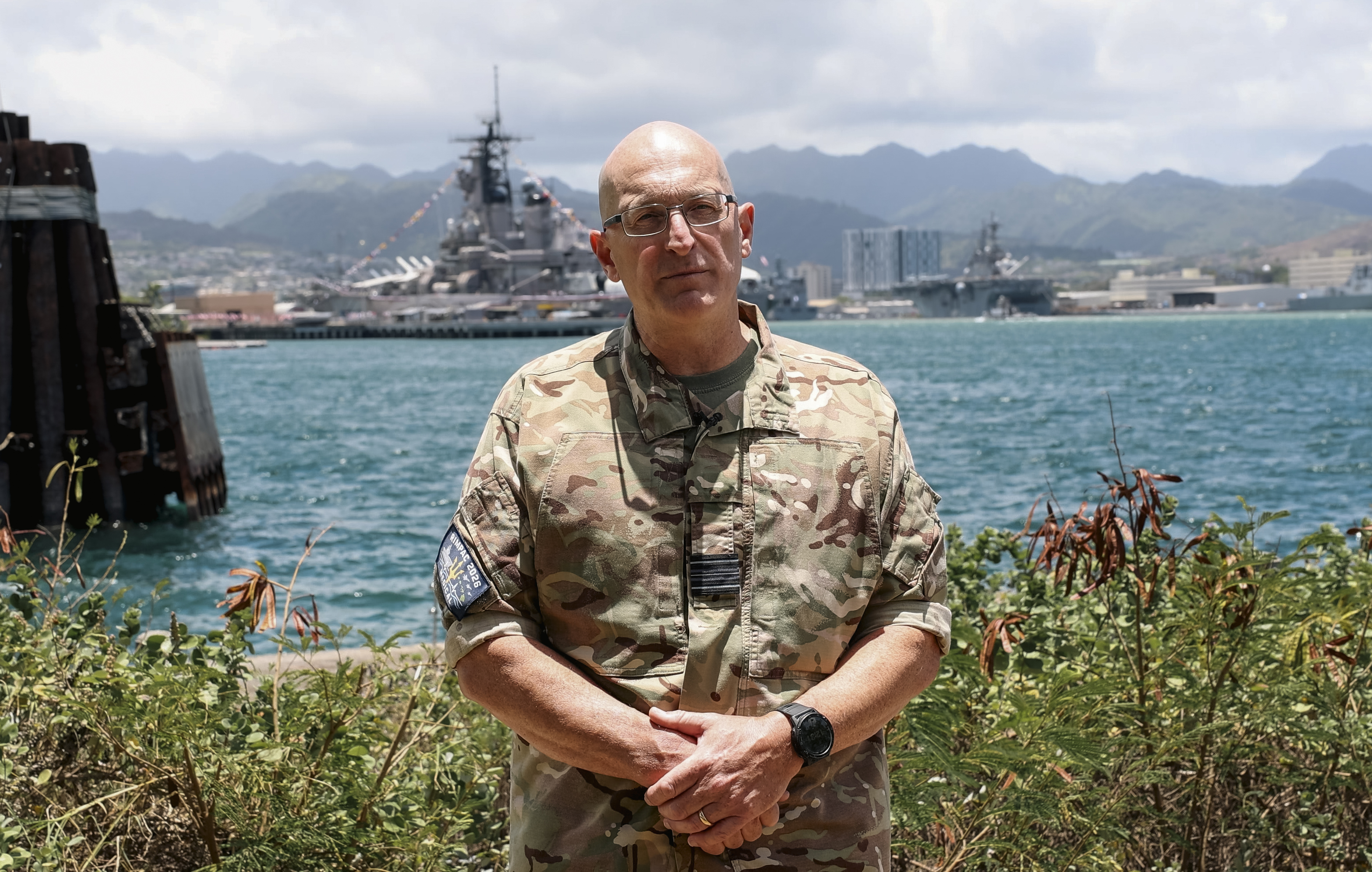An RAF officer standing with a harbour in the background