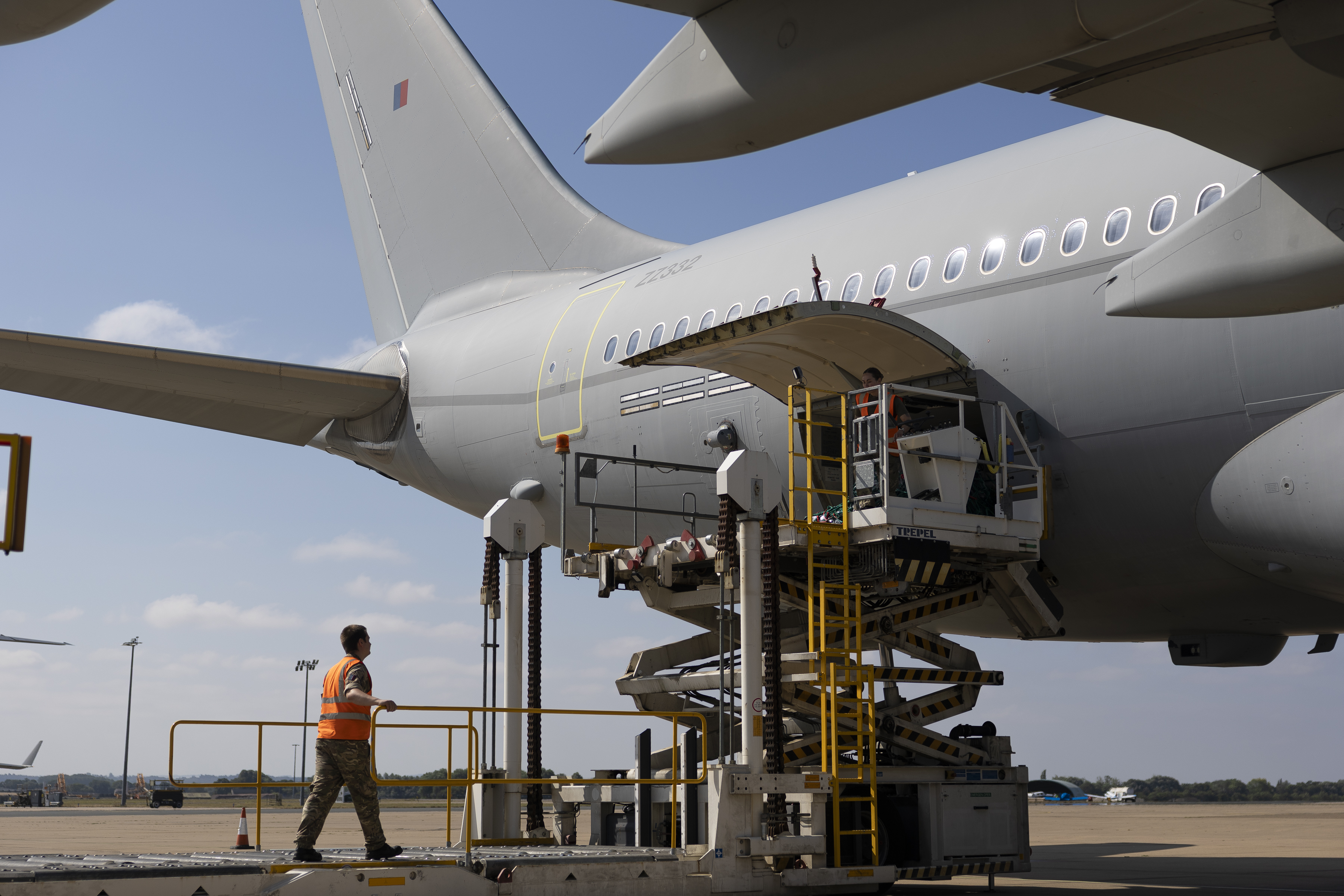 An RAF Voyager aircraft being loaded on the ground with personnel assiting.